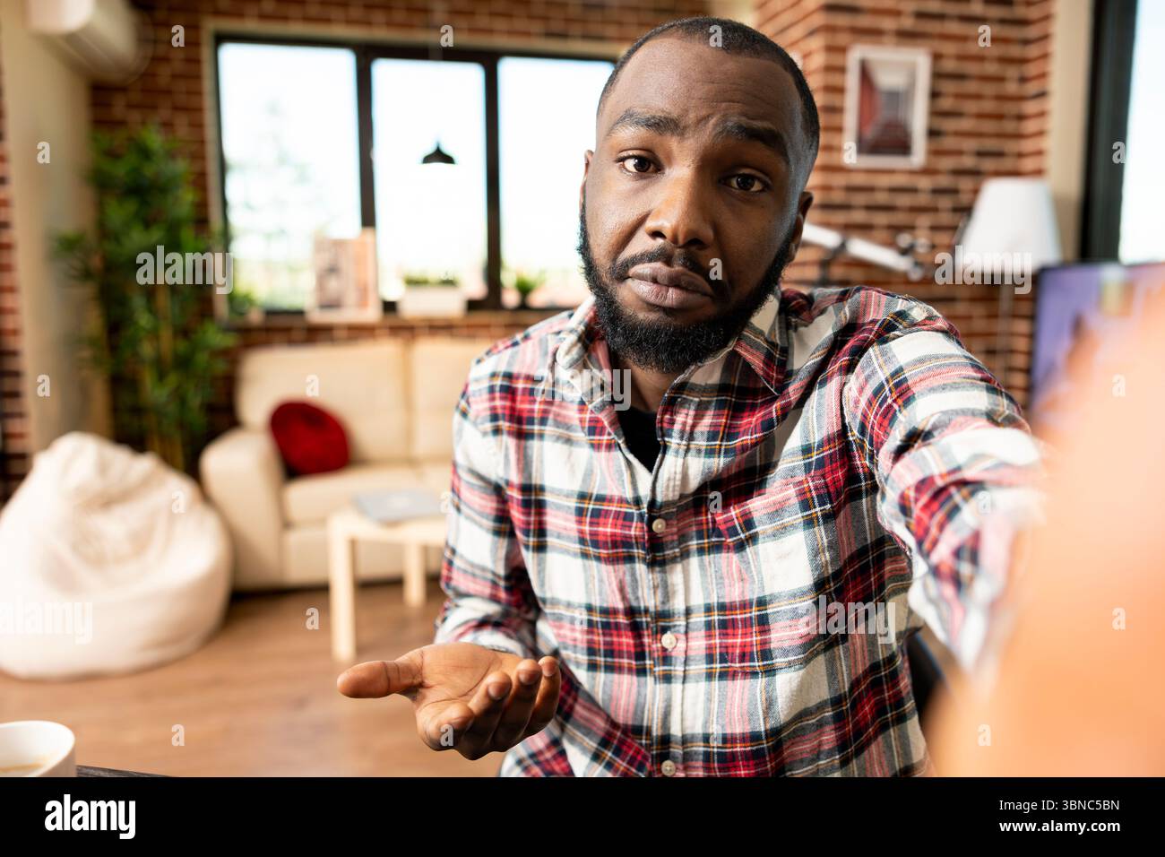 Il manager maschio remoto si sposta verso la fotocamera durante una videochiamata con il collega, discutendo gli aggiornamenti dell'azienda. L'imprenditore afroamericano detiene il cellulare, partecipando a un incontro virtuale con il cliente. Foto Stock