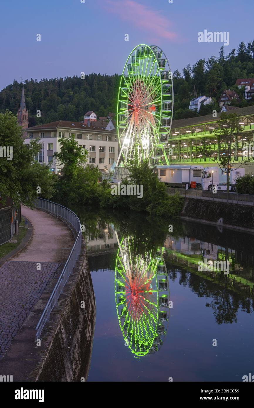 Primo piano di una ruota panoramica verde illuminata di fronte a un cielo serale con nuvole rosa, 950 anni Calw, Germania, Europa Foto Stock