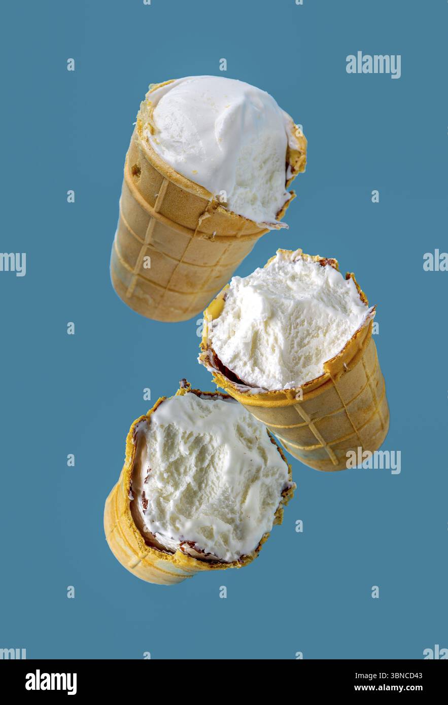 Il gelato amalgamato in tazze di cialde vola su sfondo blu Foto Stock
