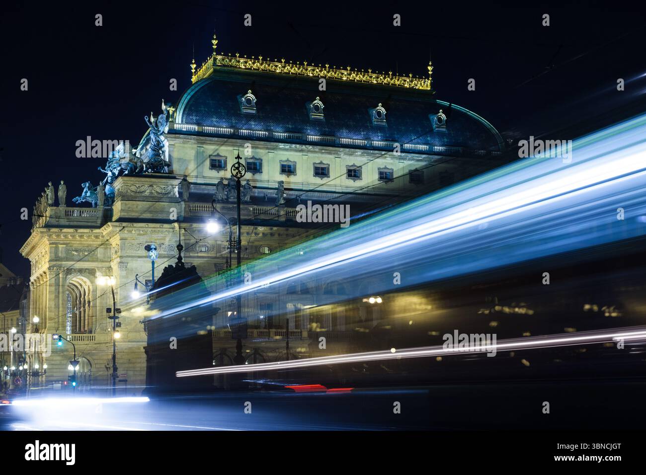 L'edificio storico classico e' illuminato da luci calde in un design piatto, con sentieri leggeri del tram Foto Stock