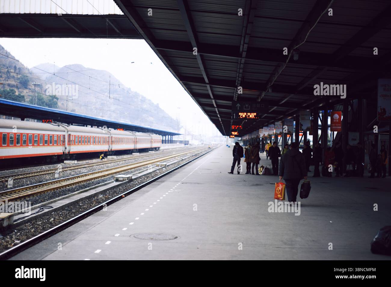 Passeggeri in attesa sul binario ferroviario della montagna alla stazione di Duyun, Guizhou Foto Stock