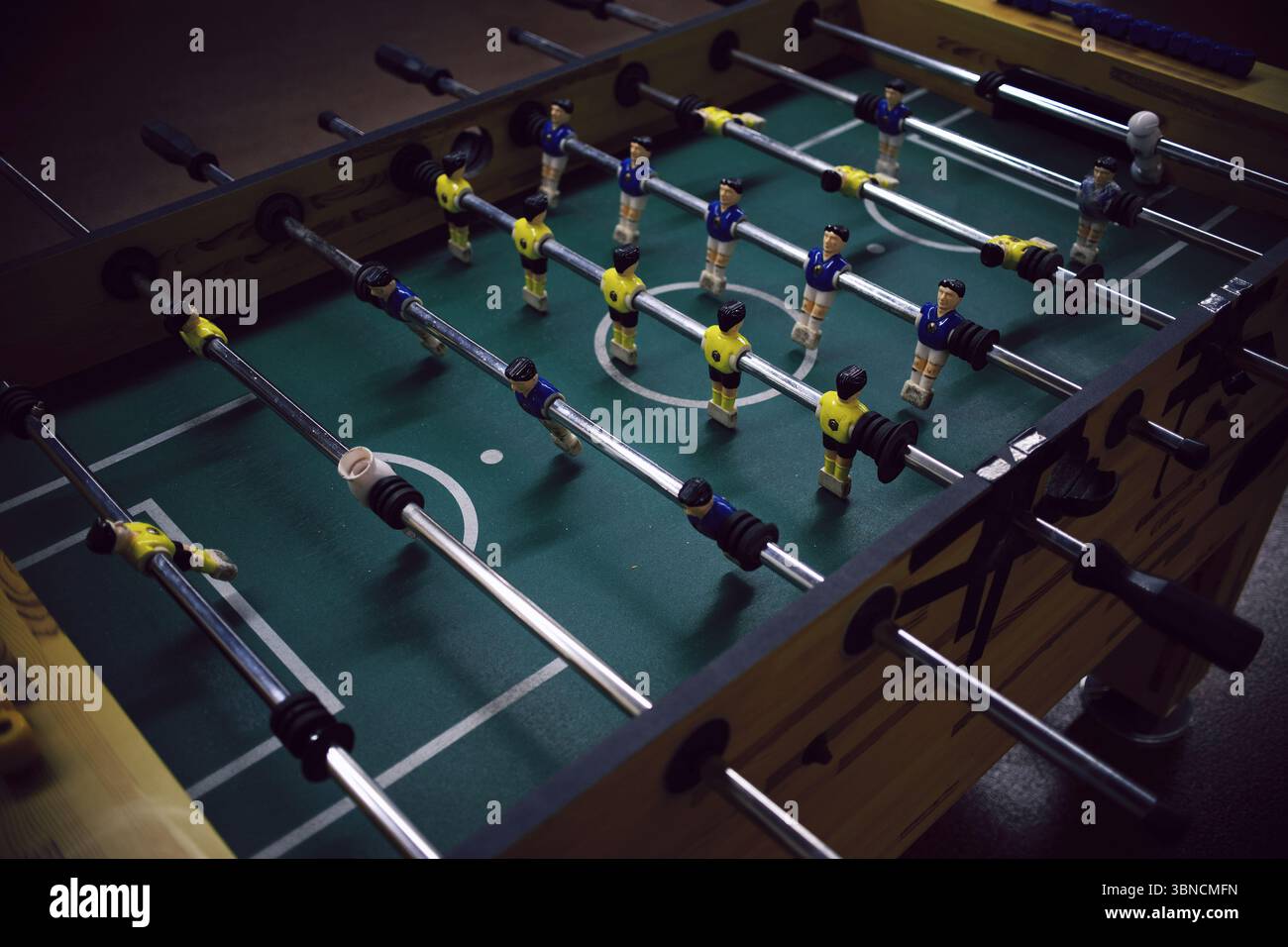 Tavolo da foosball vintage con squadre gialle e blu in gioco Foto Stock
