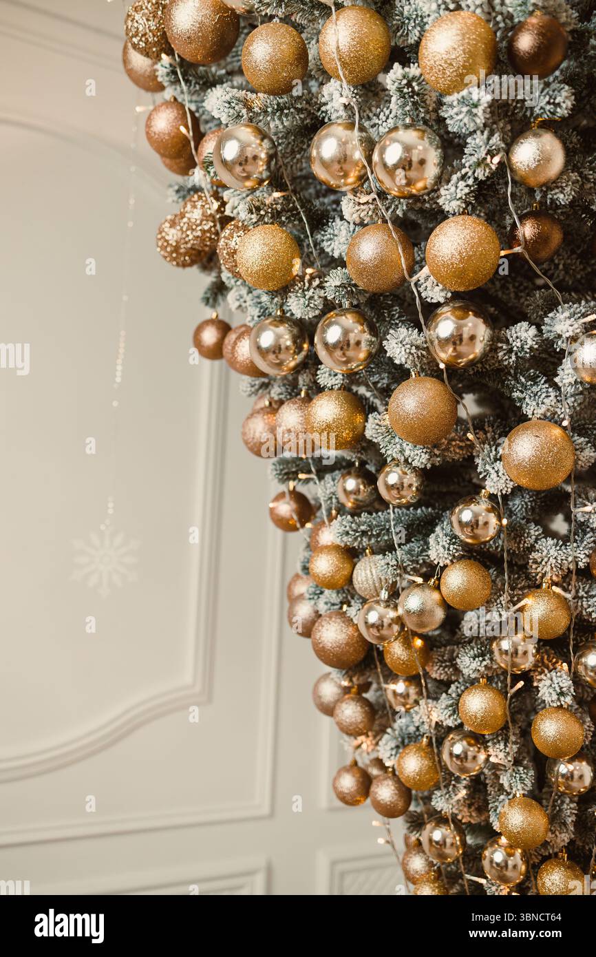 Questo splendido albero di Natale rovesciato è decorato con scintillanti ornamenti dorati, creando un'atmosfera di vacanza unica e festosa piena di gioia Foto Stock