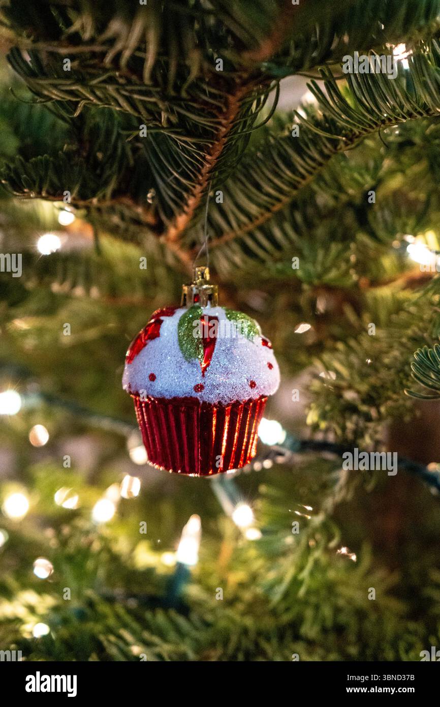Decorazioni natalizie caratterizzate da accoglienti luci natalizie, ornamenti e rami di pino che creano un'atmosfera calda e nostalgica invernale Foto Stock
