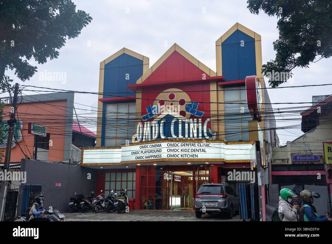 Giacarta, Indonesia - 30 gennaio 2025: Edificio con un cartello con scritto "OMDC Clinic". L'edificio e' rosso e blu con un tetto giallo. CE ne sono Foto Stock