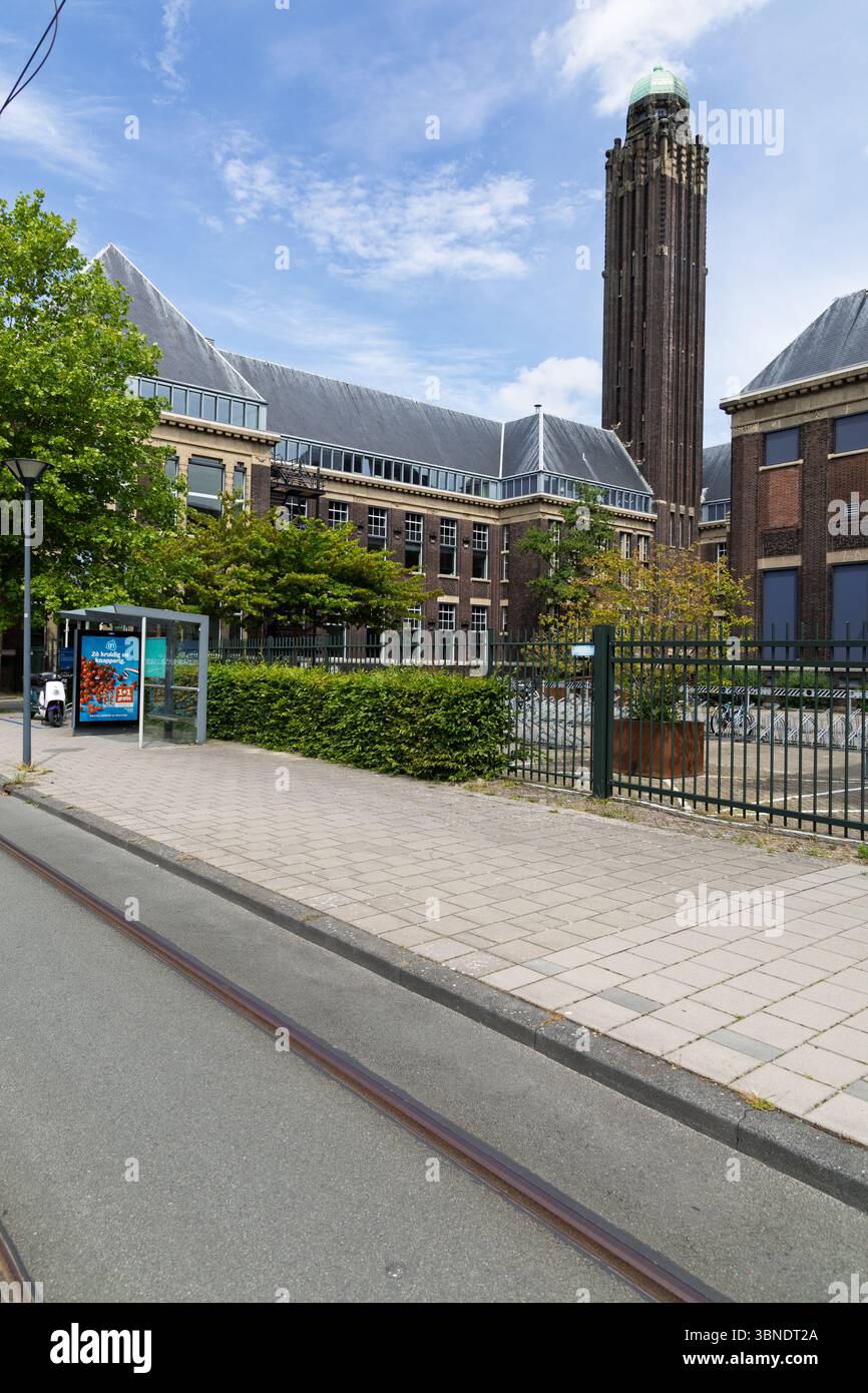 Lo storico edificio della facoltà di architettura di tu Delft, con la sua iconica torre, si erge maestosamente sotto un cielo luminoso. Delft, Paesi Bassi, 31 maggio 2025 Foto Stock