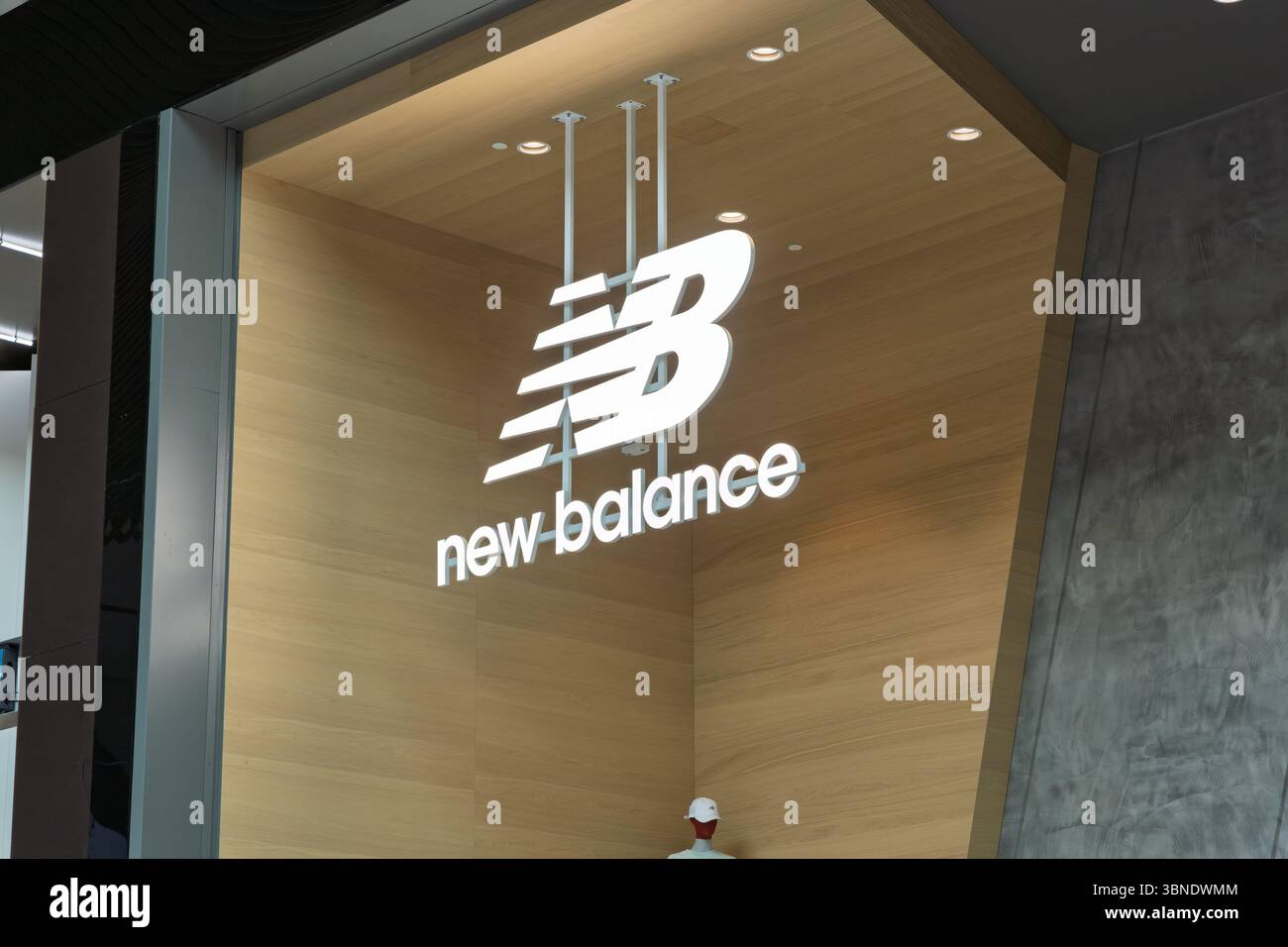 L'elegante logo New Balance si illumina all'ingresso di un moderno punto vendita, mettendo in risalto il marchio contemporaneo e la moda sportiva. Leidschendam, Netherlan Foto Stock