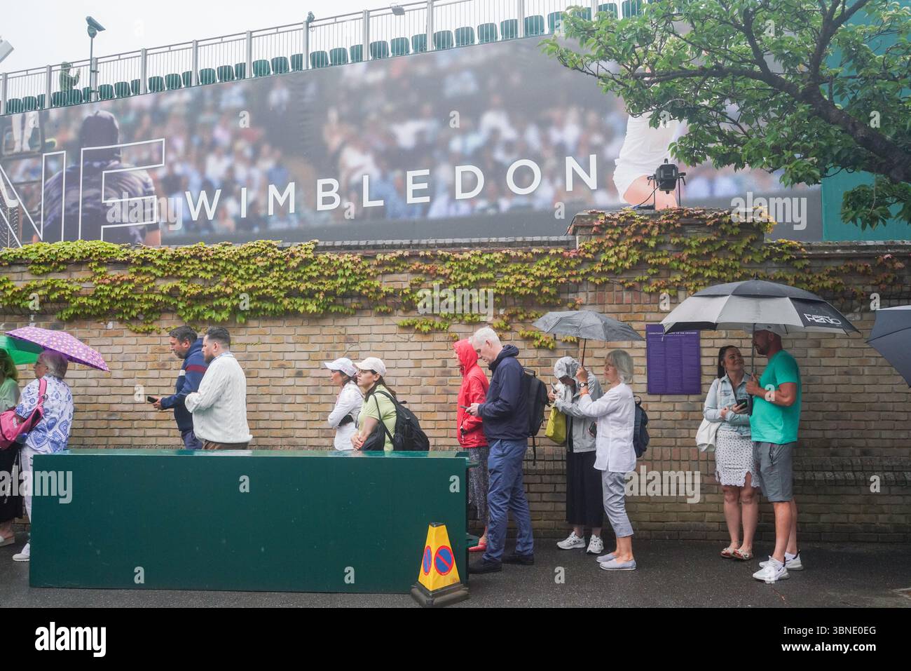 Londra, Regno Unito. 2 luglio 2025. Gli spettatori di tennis si riparano con gli ombrelli quando la pioggia cade il giorno 3 dei Campionati di Wimbledon dopo la giornata di apertura da record, quando la temperatura è salita a 33 Celsius/91 gradi Fahrenheit Amer Ghazzal/Alamy Live News Foto Stock Londra, Regno Unito. 2 luglio 2025. Gli spettatori di tennis si riparano con gli ombrelli quando la pioggia cade il giorno 3 dei Campionati di Wimbledon dopo la giornata di apertura da record, quando la temperatura è salita a 33 Celsius/91 gradi Fahrenheit Amer Ghazzal/Alamy Live News Foto Stock