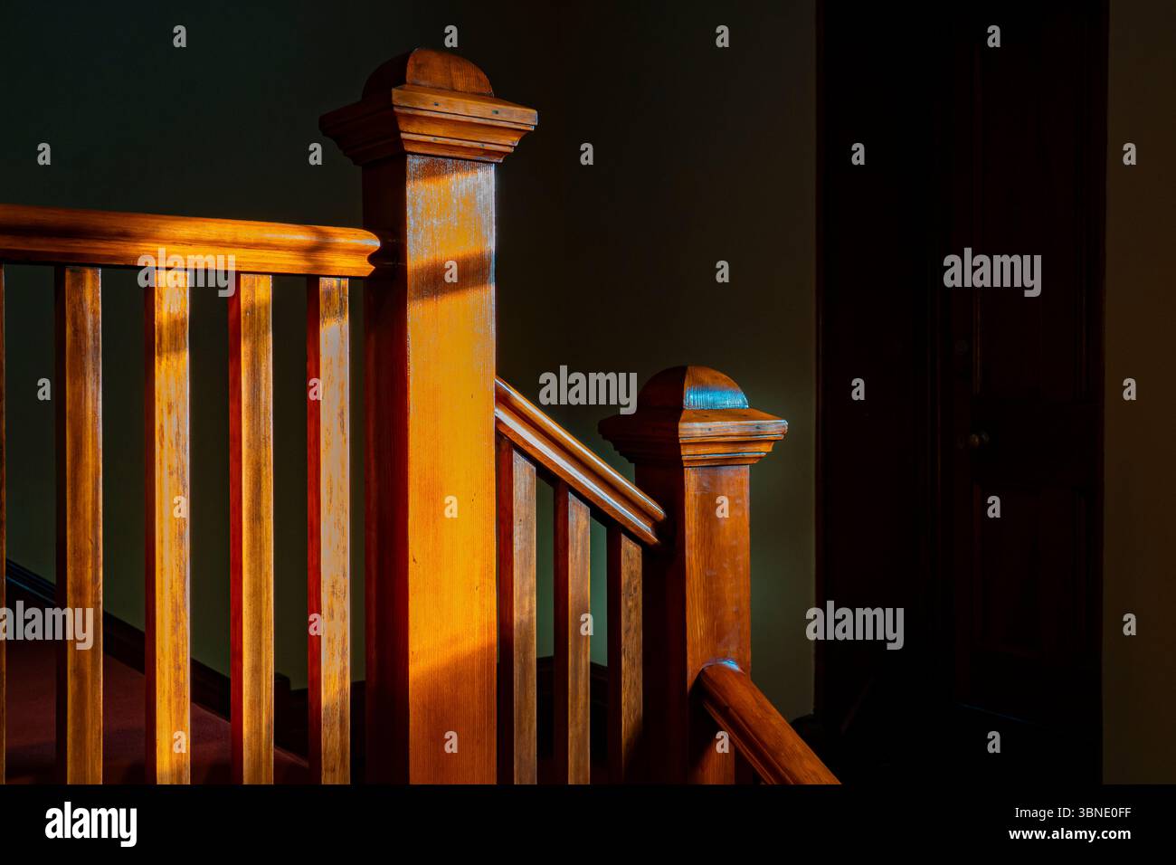 Una balaustra e una banister all'interno di uno degli edifici storici di Observatory Hill a Sydney, Australia, sono immersi nella calda luce del sole pomeridiano Foto Stock