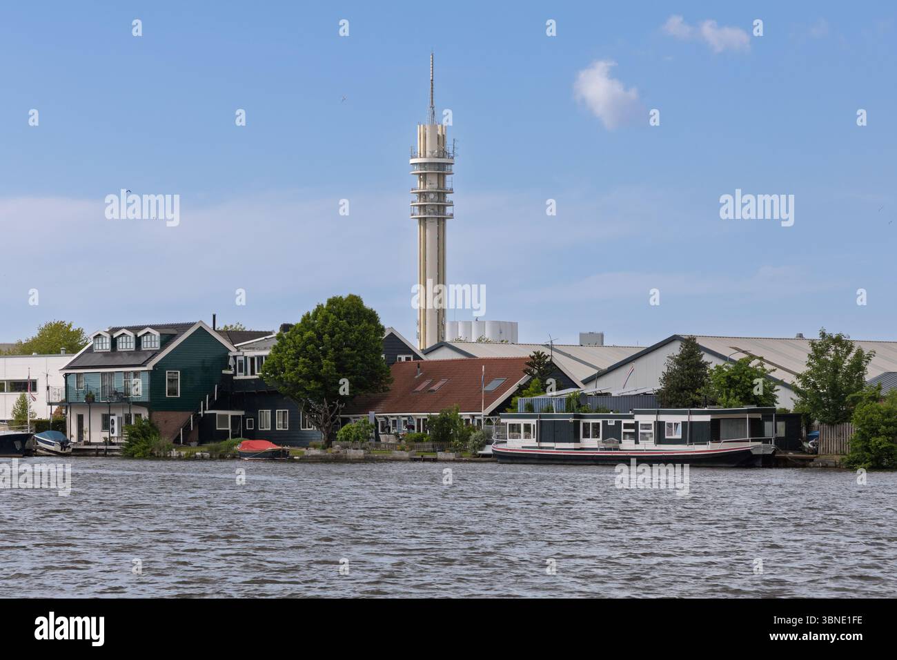 Torre delle telecomunicazioni Wormer: Vista panoramica sul lungomare nei Paesi Bassi con case tradizionali, case galleggianti e un'alta torre di comunicazione. Foto Stock