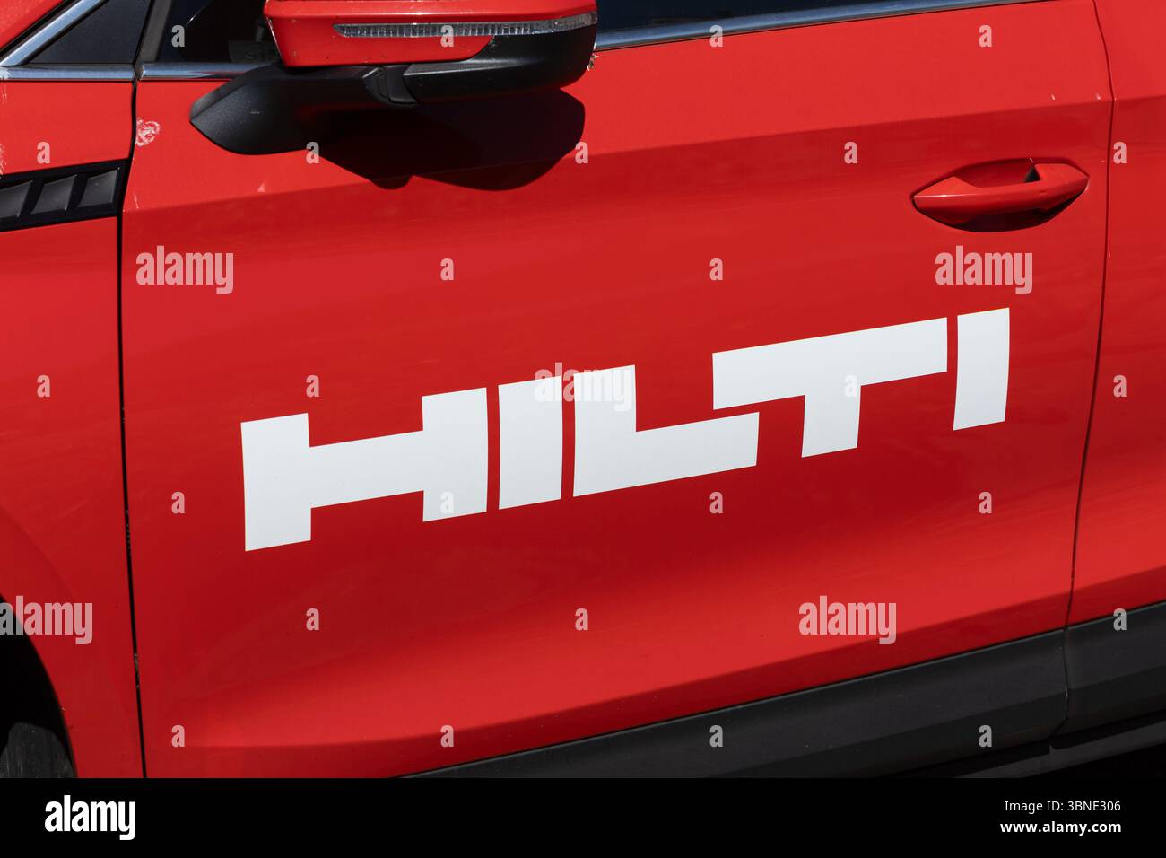 Un'auto rossa con il marchio Hilti, che mostra il logo dell'azienda sul lato, simboleggiando le soluzioni mobili e i servizi professionali nel settore edile Foto Stock