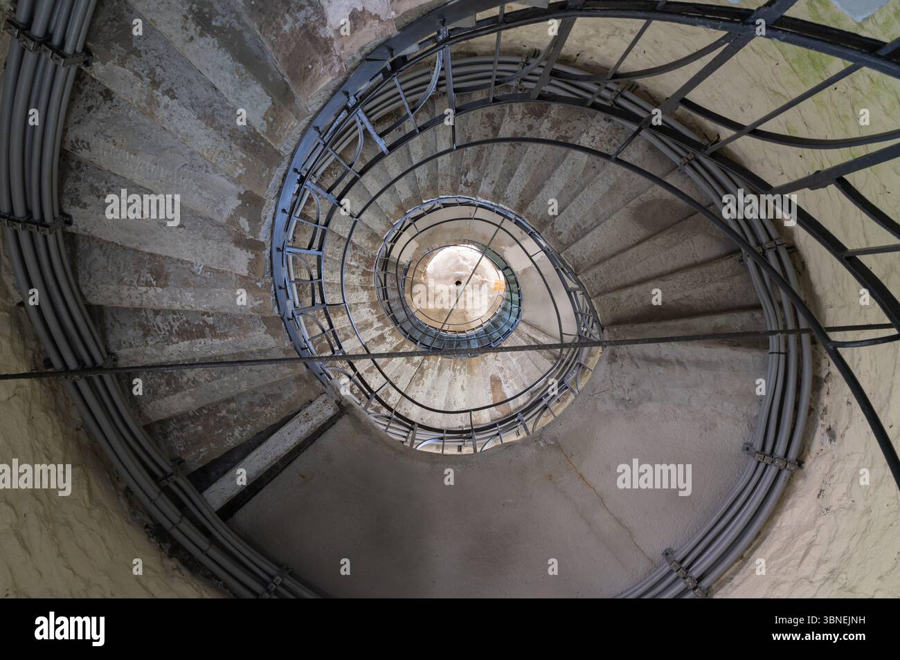 Una vista accattivante che mostra una scala a chiocciola splendidamente progettata che conduce graziosamente verso l'alto all'interno di un faro Foto Stock