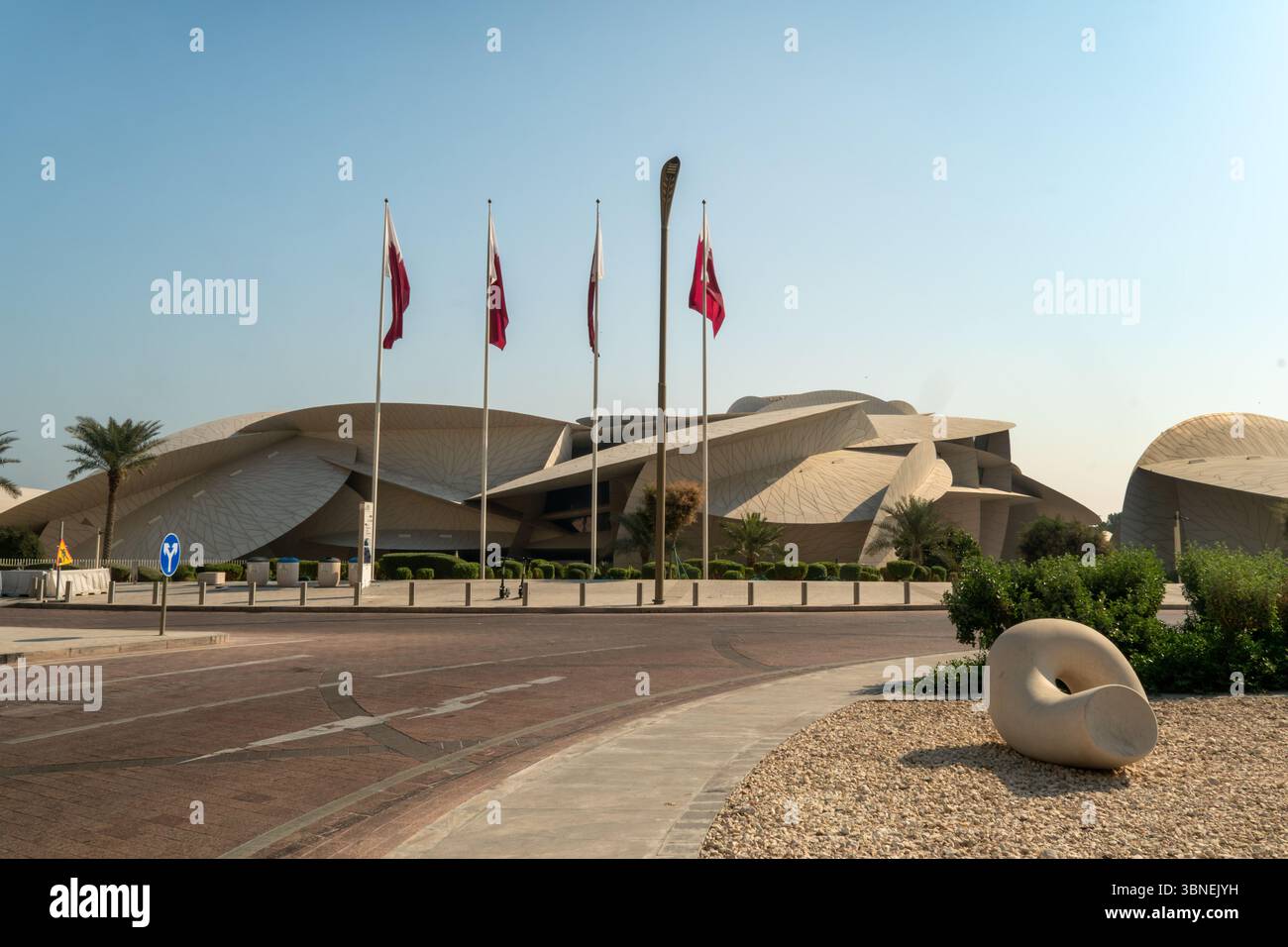1° febbraio 2025, Qatar Doha.: Museo nazionale del deserto del Qatar vista panoramica esterna sul cielo blu con bandiera nazionale del Qatar. Foto Stock