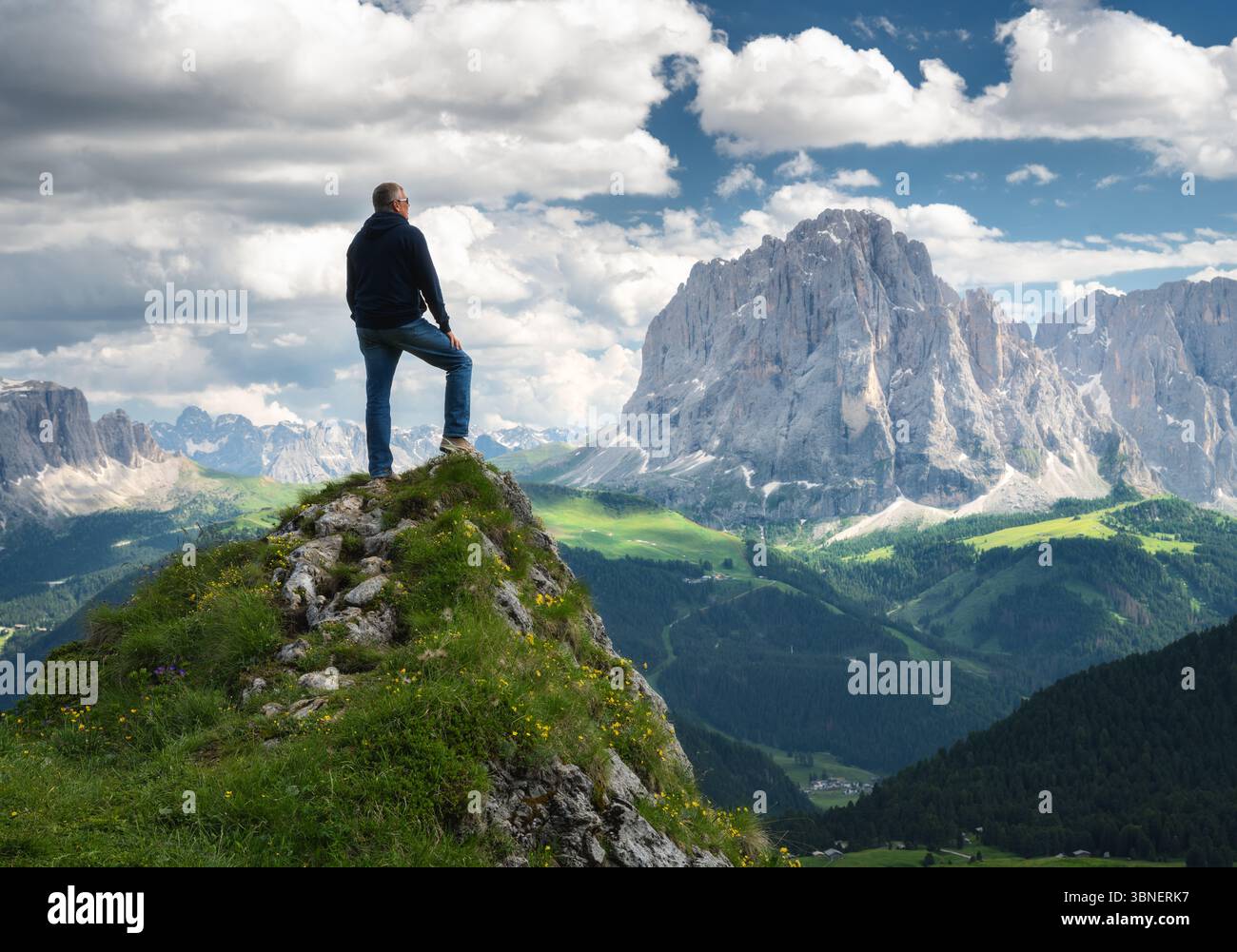 Escursionista in piedi su una vetta, catena montuosa mozzafiato Foto Stock