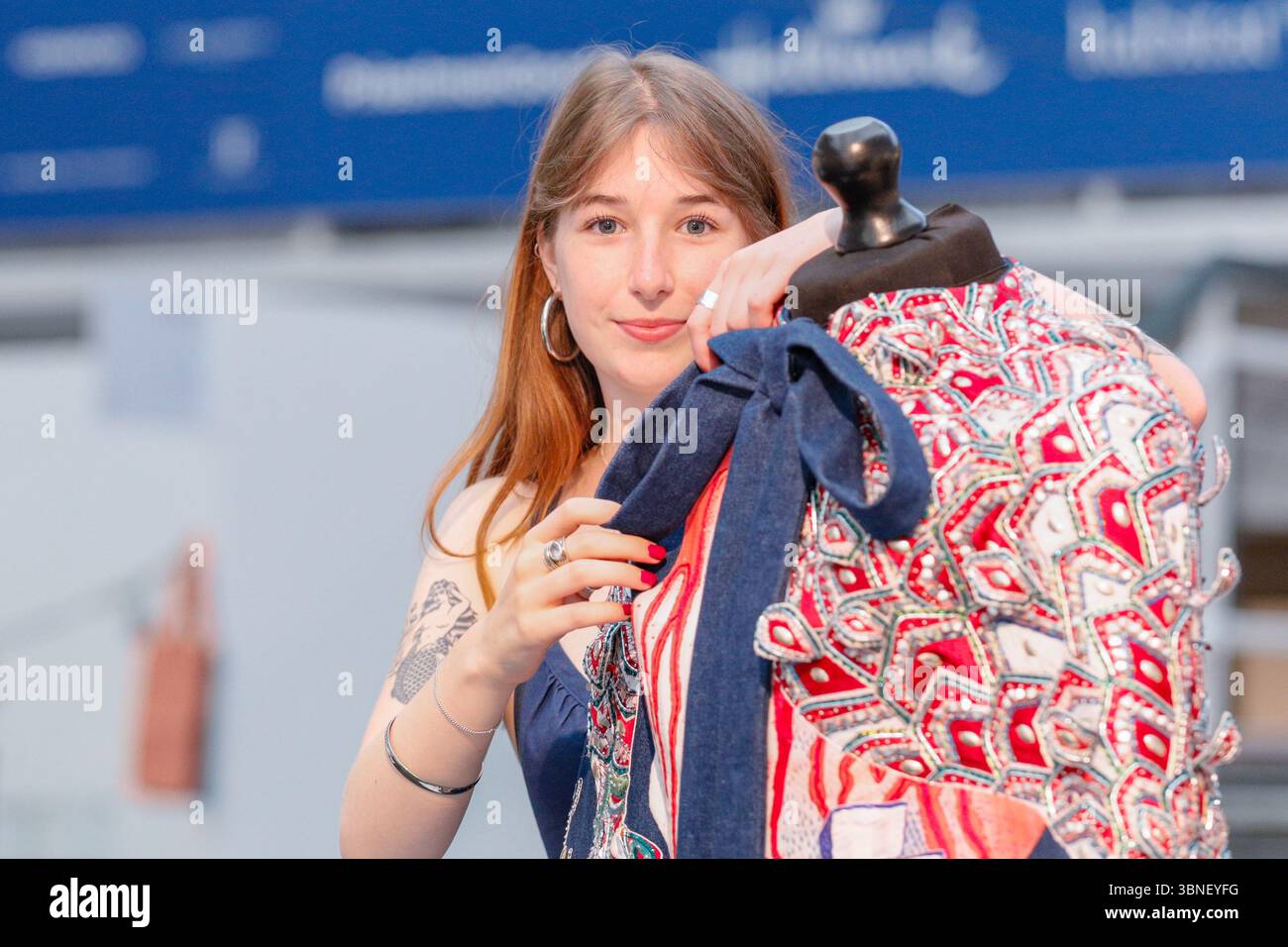 Londra, Regno Unito. 2 luglio 2025. Madelaine-Rose Walker, studentessa della Royal School of Needlework, dà il tocco finale al suo design, che presenta le parole "Fell in Love". I laureati del Regno Unito in più di 100 corsi universitari presenteranno i loro progetti dell'ultimo anno nelle prossime due settimane al Business Design Centre, mentre il New Designers Show celebra il suo 40° anniversario. Le mostre della prima settimana riguardano moda e costumi, artigianato, tessuti, gioielli e metalli, ceramiche e vetro. Crediti: Imageplotter/Alamy Live News Foto Stock