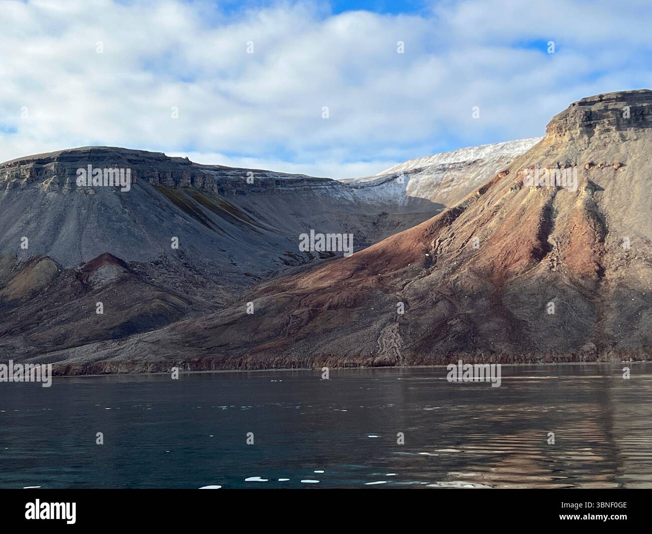 Maestose montagne innevate si riflettono nelle tranquille acque di un fiordo. Spitsbergen, Svalbard - Immagine stock catturata con smartphone