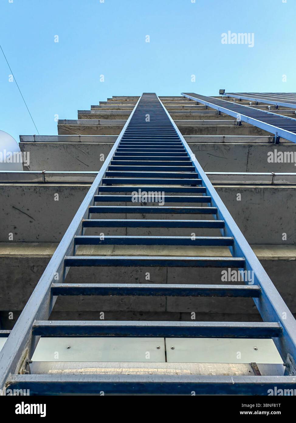 Vista ad angolo basso delle scale di emergenza in metallo. Piani dell'edificio con garage pubblico Foto Stock