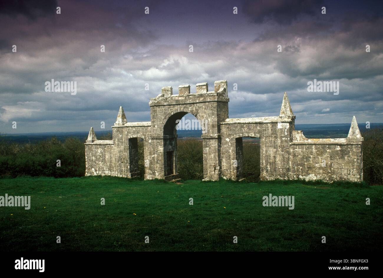 Grange Arch, noto anche come Creech Folly e Bonds Folly Creech, Dorset, è una follia del XVIII secolo che si trova vicino al secondo punto più alto delle Purbeck Hills. La follia, che fu costruita da un ex proprietario della Creech Grange, Denis Bond nel 1746. Costruito a forma di triplo arco di pietra concava. L'arco centrale è sormontato da merlature e fiancheggiato da muri in pietra con archi di accesso più piccoli. Creech vicino a Wareham, Dorset, Inghilterra, anni '1993 1990, Regno Unito, HOMER SYKES Foto Stock