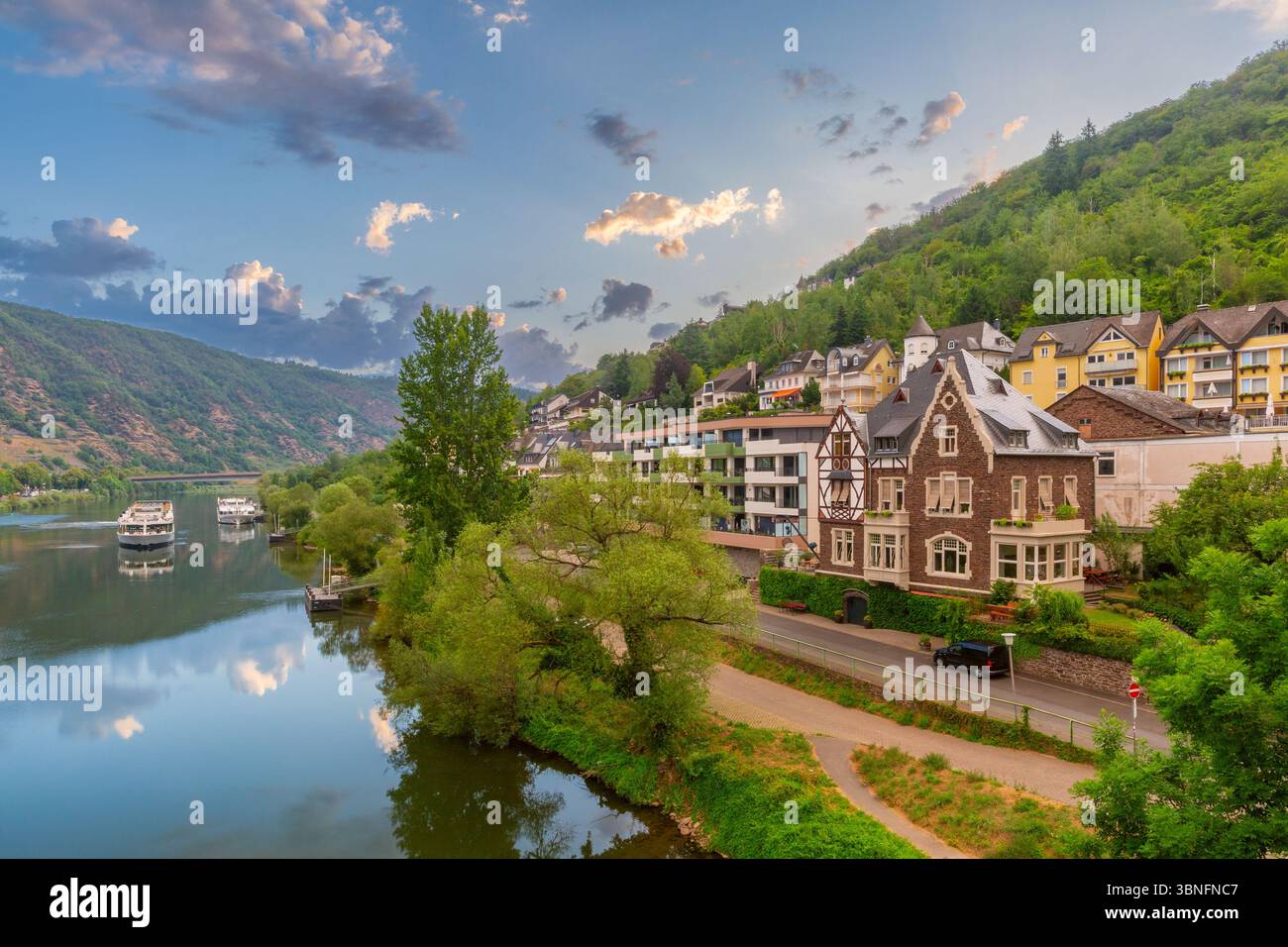 Edifici residenziali lungo il fiume Mosella con colline a Cochem, Germania Foto Stock