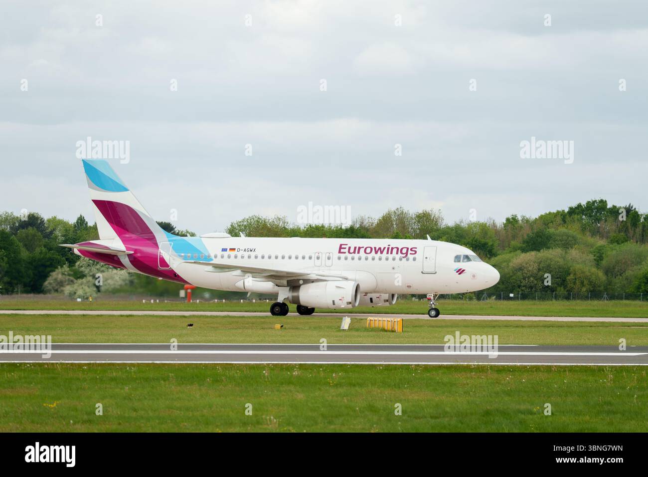 I passeggeri viaggiano su una pista, mostrando l'emblema di Eurowings, nuvole in alto, raffiguranti l'aviazione e i trasporti. Foto Stock