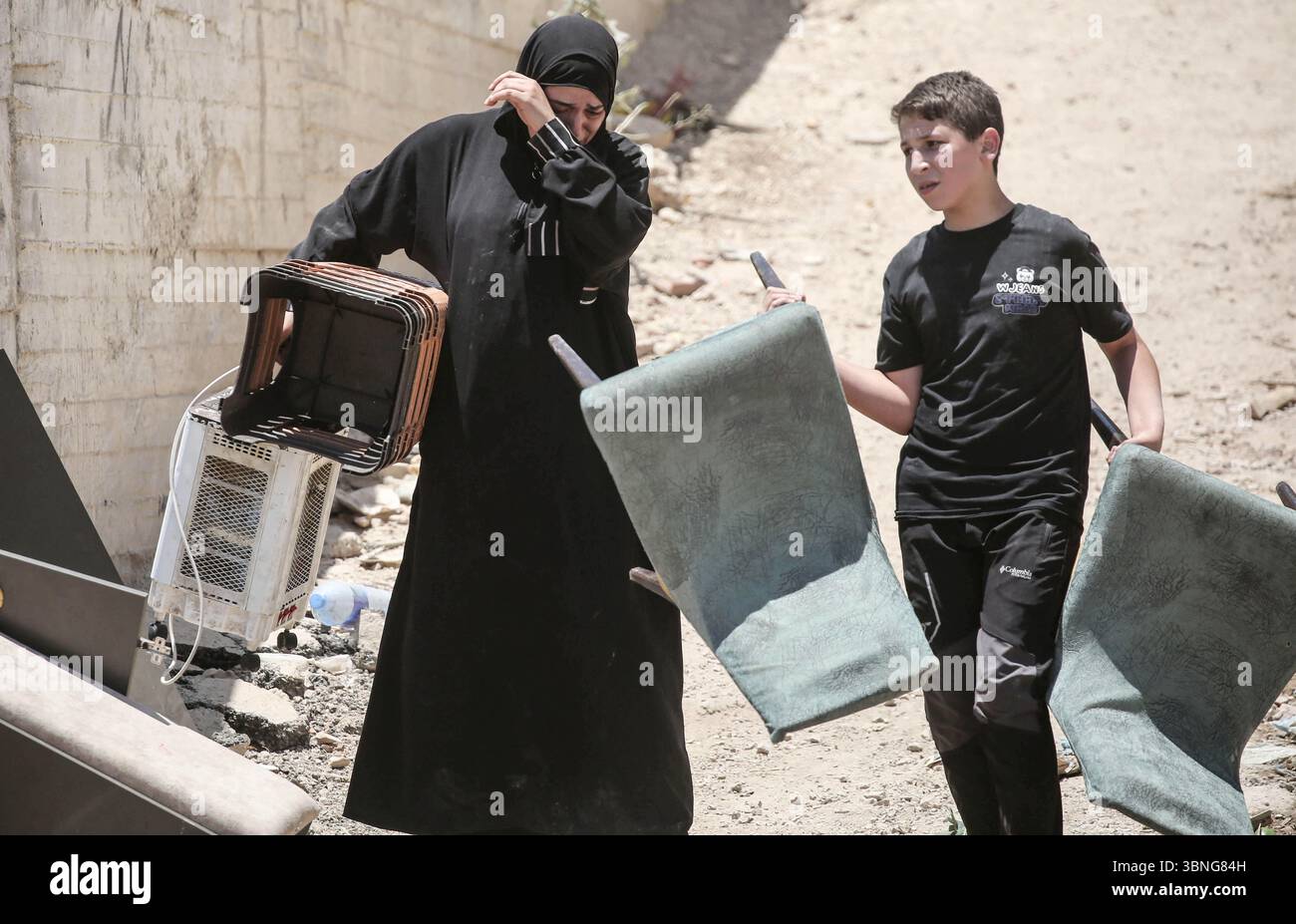 Tulkarm, Palestina. 2 luglio 2025. Le famiglie palestinesi portano con sé i loro effetti personali mentre fuggono dal campo profughi di Tulkarm. Le forze israeliane hanno permesso ai residenti di recuperare i loro effetti personali dopo aver emesso avvisi di demolizione per diverse case, nel mezzo di un'offensiva durata mesi in Cisgiordania che ha allontanato circa 35.000 palestinesi dalle loro case nel campo profughi di Tulkarm. Credito: SOPA Images Limited/Alamy Live News Foto Stock