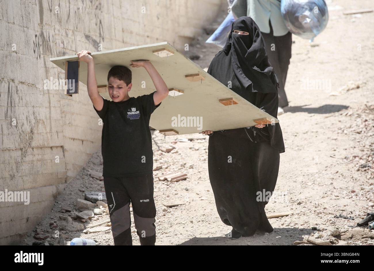 Tulkarm, Palestina. 2 luglio 2025. Le famiglie palestinesi portano con sé i loro effetti personali mentre fuggono dal campo profughi di Tulkarm. Le forze israeliane hanno permesso ai residenti di recuperare i loro effetti personali dopo aver emesso avvisi di demolizione per diverse case, nel mezzo di un'offensiva durata mesi in Cisgiordania che ha allontanato circa 35.000 palestinesi dalle loro case nel campo profughi di Tulkarm. Credito: SOPA Images Limited/Alamy Live News Foto Stock