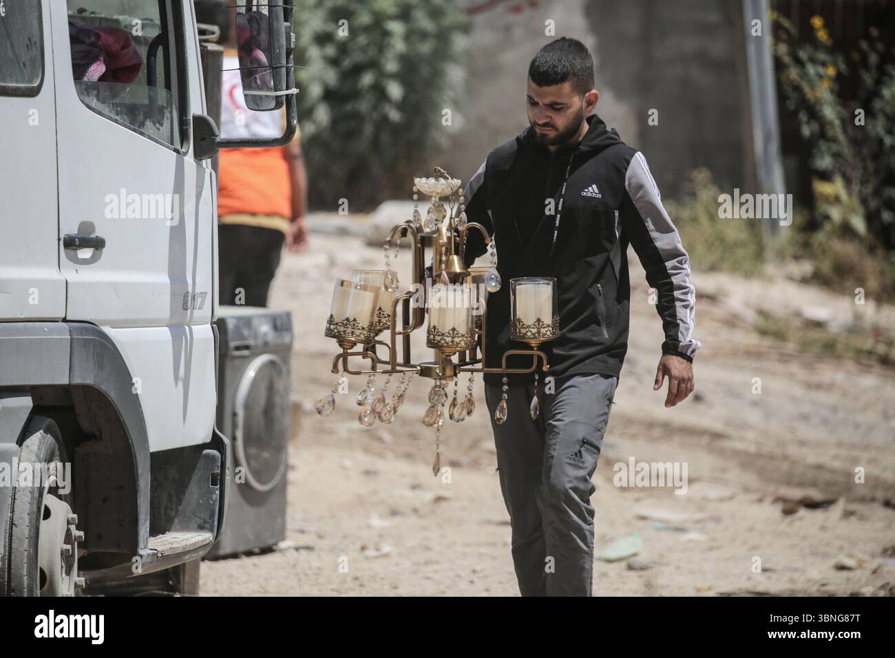 Tulkarm, Palestina. 2 luglio 2025. Un palestinese porta i suoi effetti personali mentre fugge dal campo profughi di Tulkarm. Le forze israeliane hanno permesso ai residenti di recuperare i loro effetti personali dopo aver emesso avvisi di demolizione per diverse case, nel mezzo di un'offensiva durata mesi in Cisgiordania che ha allontanato circa 35.000 palestinesi dalle loro case nel campo profughi di Tulkarm. Credito: SOPA Images Limited/Alamy Live News Foto Stock
