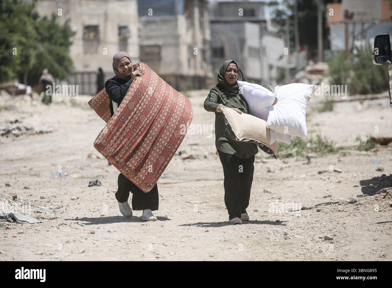 Tulkarm, Palestina. 2 luglio 2025. Le famiglie palestinesi portano con sé i loro effetti personali mentre fuggono dal campo profughi di Tulkarm. Le forze israeliane hanno permesso ai residenti di recuperare i loro effetti personali dopo aver emesso avvisi di demolizione per diverse case, nel mezzo di un'offensiva durata mesi in Cisgiordania che ha allontanato circa 35.000 palestinesi dalle loro case nel campo profughi di Tulkarm. Credito: SOPA Images Limited/Alamy Live News Foto Stock
