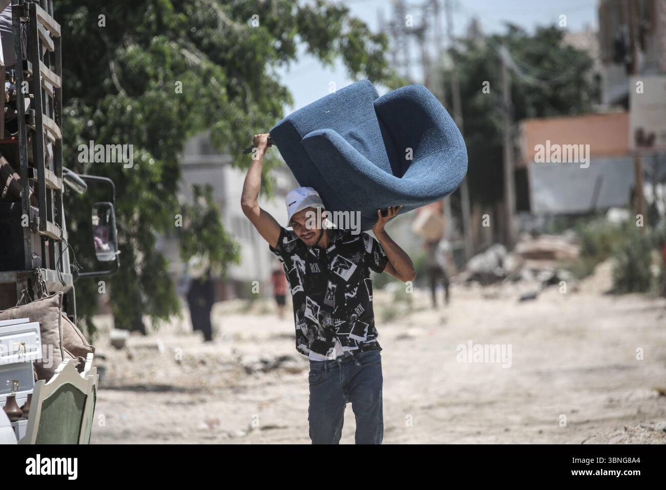 Tulkarm, Palestina. 2 luglio 2025. Un palestinese porta i suoi effetti personali mentre fugge dal campo profughi di Tulkarm. Le forze israeliane hanno permesso ai residenti di recuperare i loro effetti personali dopo aver emesso avvisi di demolizione per diverse case, nel mezzo di un'offensiva durata mesi in Cisgiordania che ha allontanato circa 35.000 palestinesi dalle loro case nel campo profughi di Tulkarm. Credito: SOPA Images Limited/Alamy Live News Foto Stock