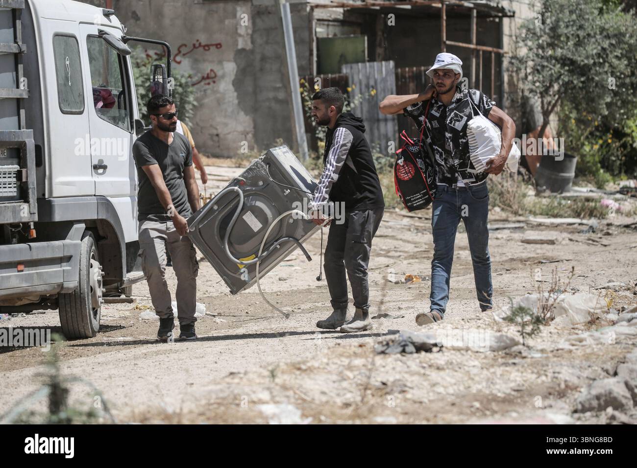 Tulkarm, Palestina. 2 luglio 2025. Le famiglie palestinesi portano con sé i loro effetti personali mentre fuggono dal campo profughi di Tulkarm. Le forze israeliane hanno permesso ai residenti di recuperare i loro effetti personali dopo aver emesso avvisi di demolizione per diverse case, nel mezzo di un'offensiva durata mesi in Cisgiordania che ha allontanato circa 35.000 palestinesi dalle loro case nel campo profughi di Tulkarm. Credito: SOPA Images Limited/Alamy Live News Foto Stock