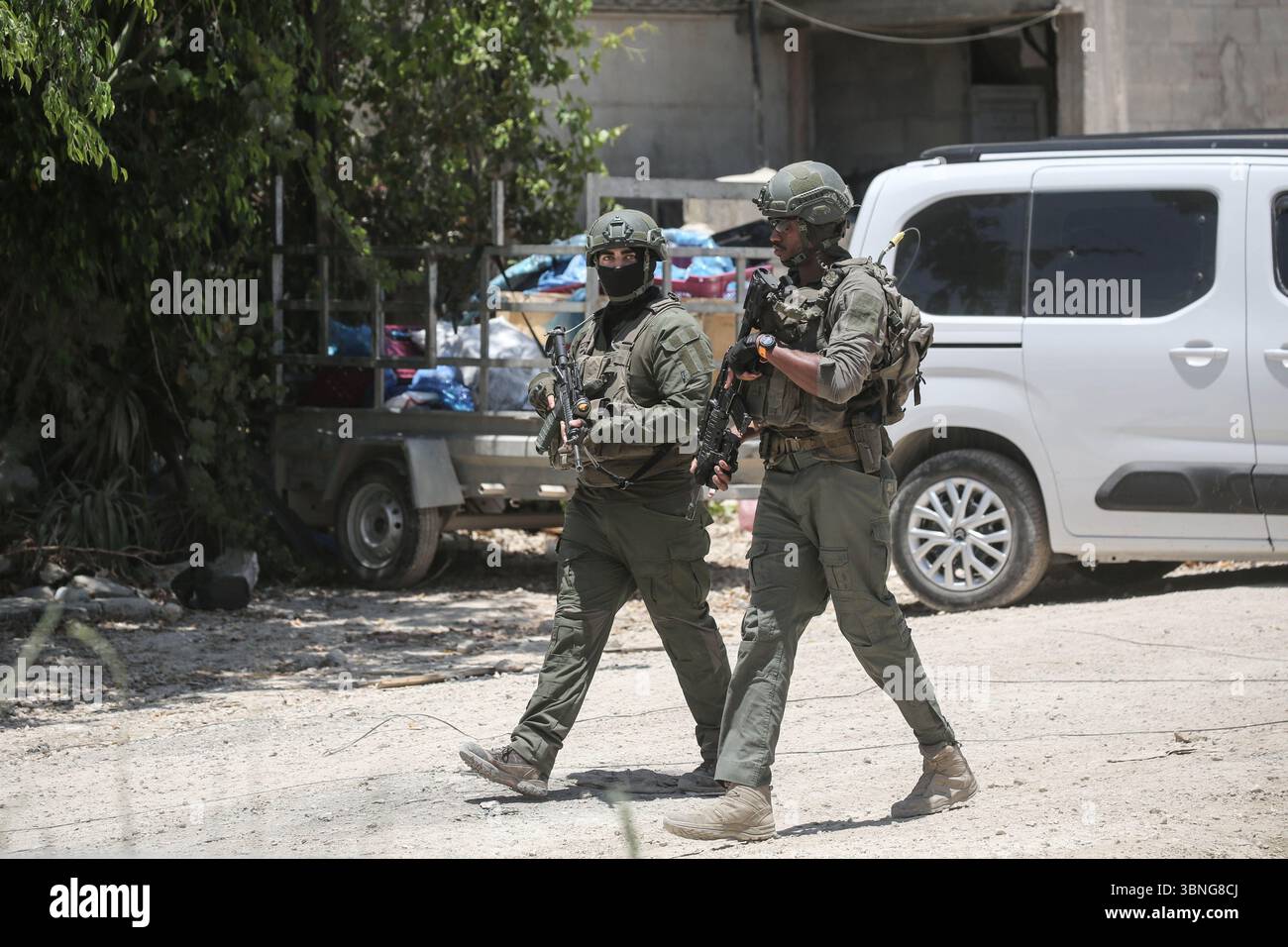 Tulkarm, Palestina. 2 luglio 2025. I soldati israeliani proteggono le famiglie palestinesi in fuga dal campo profughi di Tulkarm. Le forze israeliane hanno permesso ai residenti di recuperare i loro effetti personali dopo aver emesso avvisi di demolizione per diverse case, nel mezzo di un'offensiva durata mesi in Cisgiordania che ha allontanato circa 35.000 palestinesi dalle loro case nel campo profughi di Tulkarm. Credito: SOPA Images Limited/Alamy Live News Foto Stock