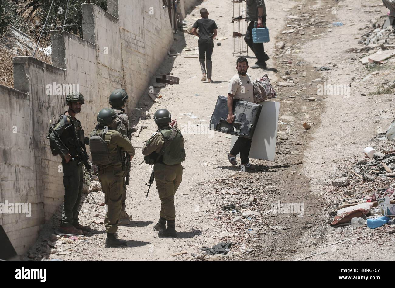 Tulkarm, Palestina. 2 luglio 2025. Le famiglie palestinesi portano con sé i loro effetti personali mentre fuggono dal campo profughi di Tulkarm. Le forze israeliane hanno permesso ai residenti di recuperare i loro effetti personali dopo aver emesso avvisi di demolizione per diverse case, nel mezzo di un'offensiva durata mesi in Cisgiordania che ha allontanato circa 35.000 palestinesi dalle loro case nel campo profughi di Tulkarm. Credito: SOPA Images Limited/Alamy Live News Foto Stock