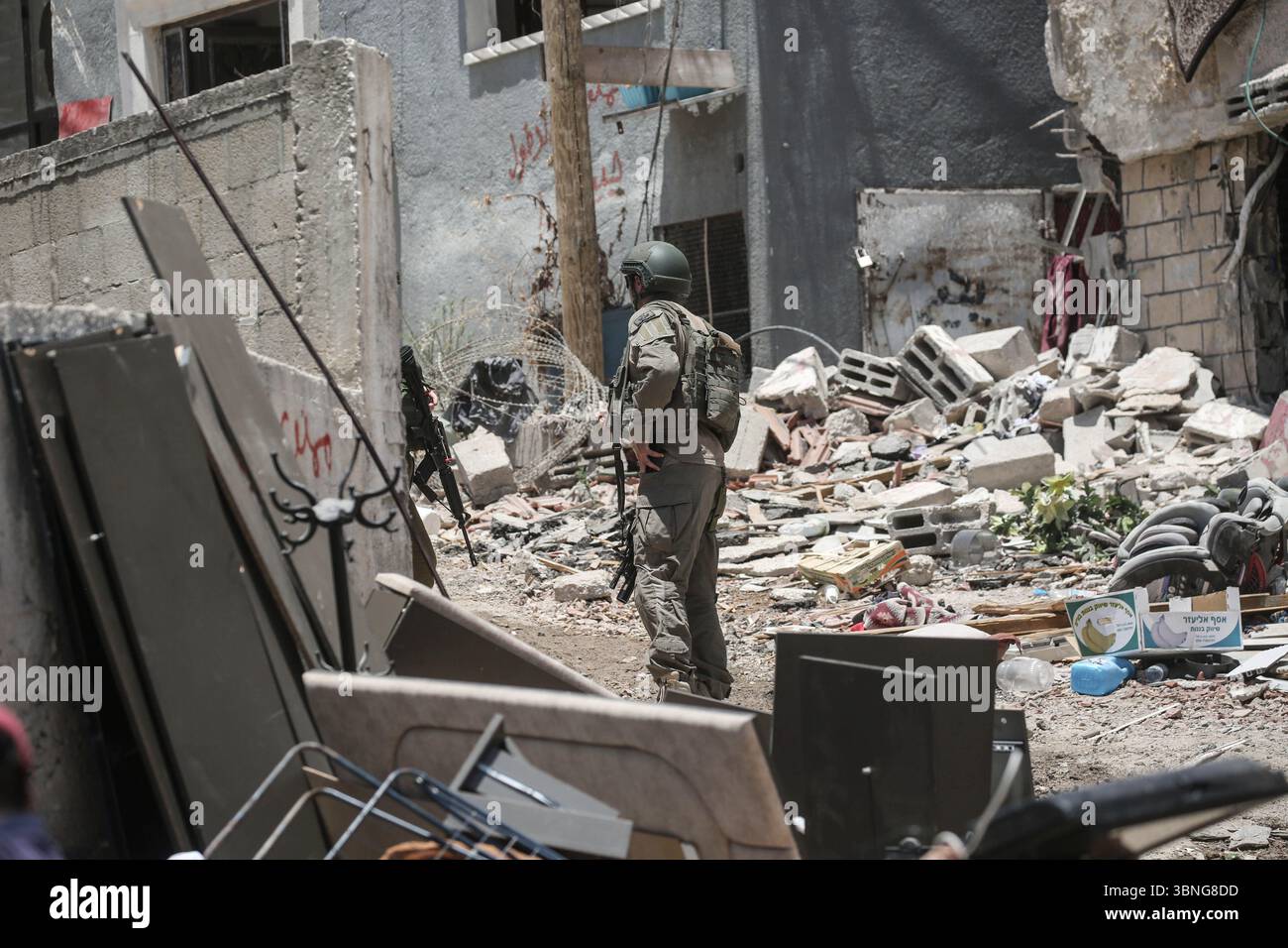 Tulkarm, Palestina. 2 luglio 2025. I soldati israeliani proteggono le famiglie palestinesi in fuga dal campo profughi di Tulkarm. Le forze israeliane hanno permesso ai residenti di recuperare i loro effetti personali dopo aver emesso avvisi di demolizione per diverse case, nel mezzo di un'offensiva durata mesi in Cisgiordania che ha allontanato circa 35.000 palestinesi dalle loro case nel campo profughi di Tulkarm. Credito: SOPA Images Limited/Alamy Live News Foto Stock