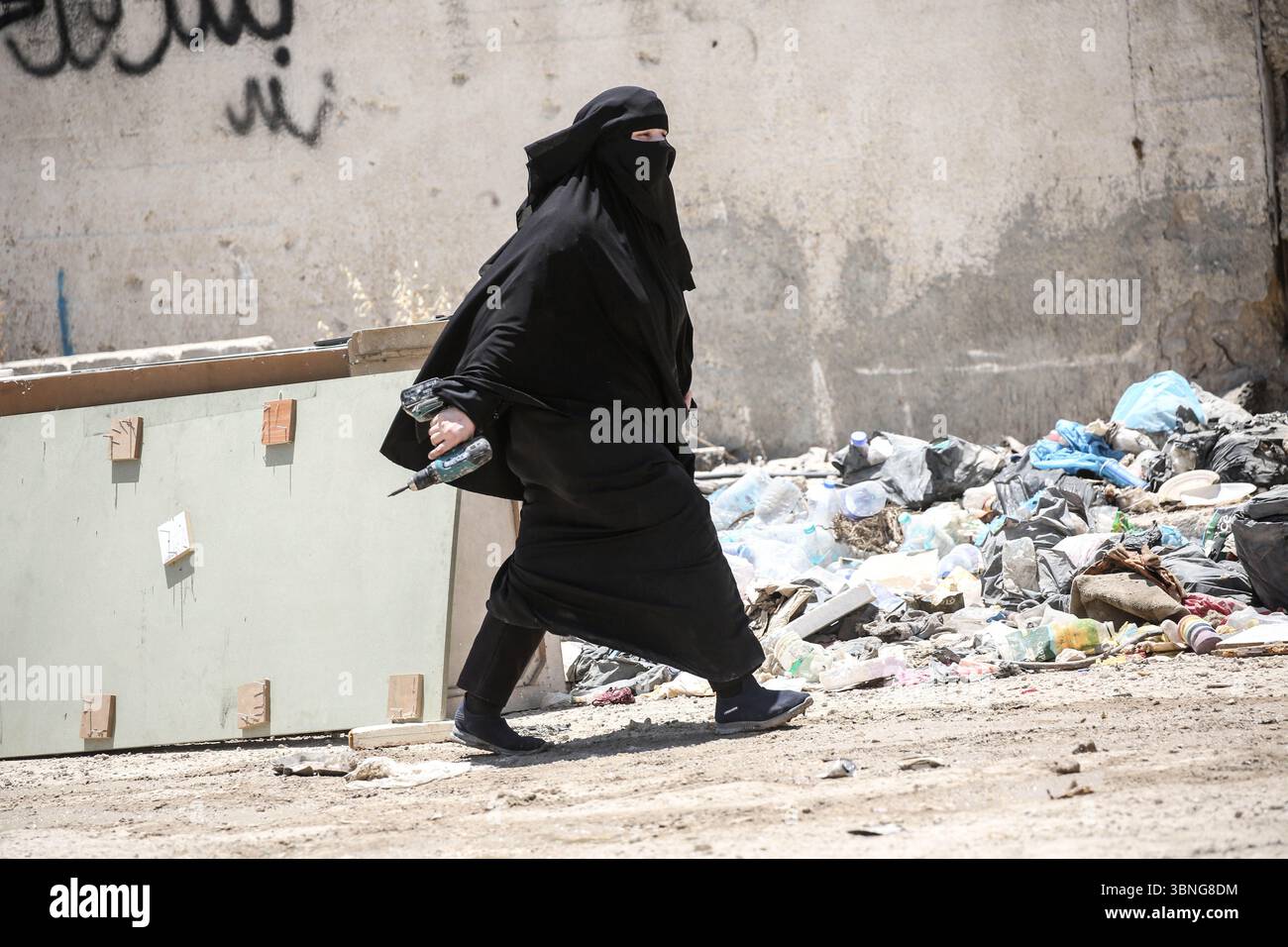 Tulkarm, Palestina. 2 luglio 2025. Una donna palestinese fugge dal campo profughi di Tulkarm. Le forze israeliane hanno permesso ai residenti di recuperare i loro effetti personali dopo aver emesso avvisi di demolizione per diverse case, nel mezzo di un'offensiva durata mesi in Cisgiordania che ha allontanato circa 35.000 palestinesi dalle loro case nel campo profughi di Tulkarm. Credito: SOPA Images Limited/Alamy Live News Foto Stock