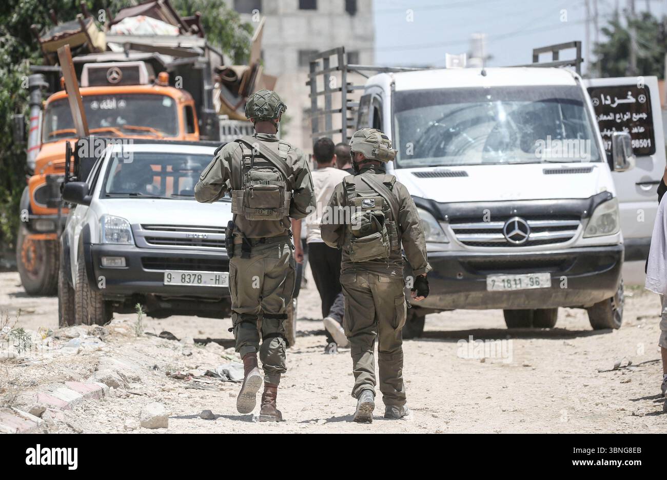Tulkarm, Palestina. 2 luglio 2025. I soldati israeliani proteggono le famiglie palestinesi in fuga dal campo profughi di Tulkarm. Le forze israeliane hanno permesso ai residenti di recuperare i loro effetti personali dopo aver emesso avvisi di demolizione per diverse case, nel mezzo di un'offensiva durata mesi in Cisgiordania che ha allontanato circa 35.000 palestinesi dalle loro case nel campo profughi di Tulkarm. Credito: SOPA Images Limited/Alamy Live News Foto Stock