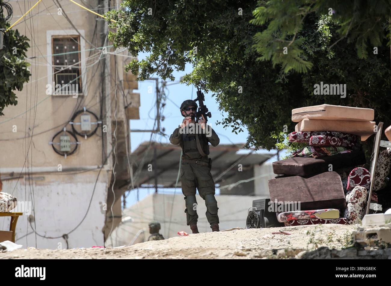 Tulkarm, Palestina. 2 luglio 2025. I soldati israeliani proteggono le famiglie palestinesi in fuga dal campo profughi di Tulkarm. Le forze israeliane hanno permesso ai residenti di recuperare i loro effetti personali dopo aver emesso avvisi di demolizione per diverse case, nel mezzo di un'offensiva durata mesi in Cisgiordania che ha allontanato circa 35.000 palestinesi dalle loro case nel campo profughi di Tulkarm. Credito: SOPA Images Limited/Alamy Live News Foto Stock