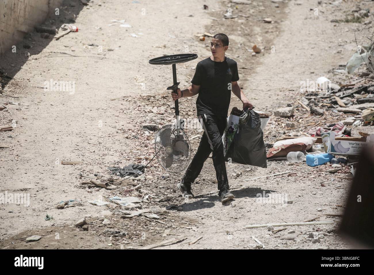 Tulkarm, Palestina. 2 luglio 2025. Un palestinese porta i suoi effetti personali mentre fugge dal campo profughi di Tulkarm. Le forze israeliane hanno permesso ai residenti di recuperare i loro effetti personali dopo aver emesso avvisi di demolizione per diverse case, nel mezzo di un'offensiva durata mesi in Cisgiordania che ha allontanato circa 35.000 palestinesi dalle loro case nel campo profughi di Tulkarm. Credito: SOPA Images Limited/Alamy Live News Foto Stock