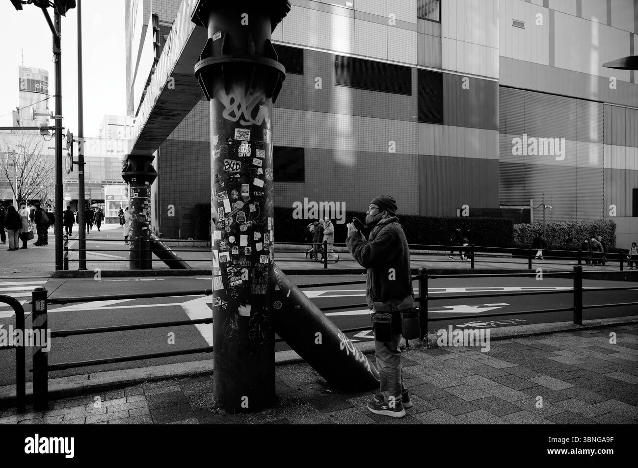 Fotografo che cattura i dettagli urbani di un pilastro con graffiti ad Akihabara Foto Stock
