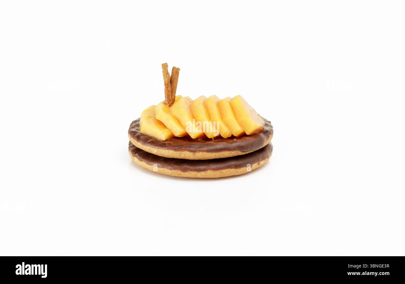 Due biscotti al cioccolato con papaya a fette decorati con bastoncini di cannella Foto Stock