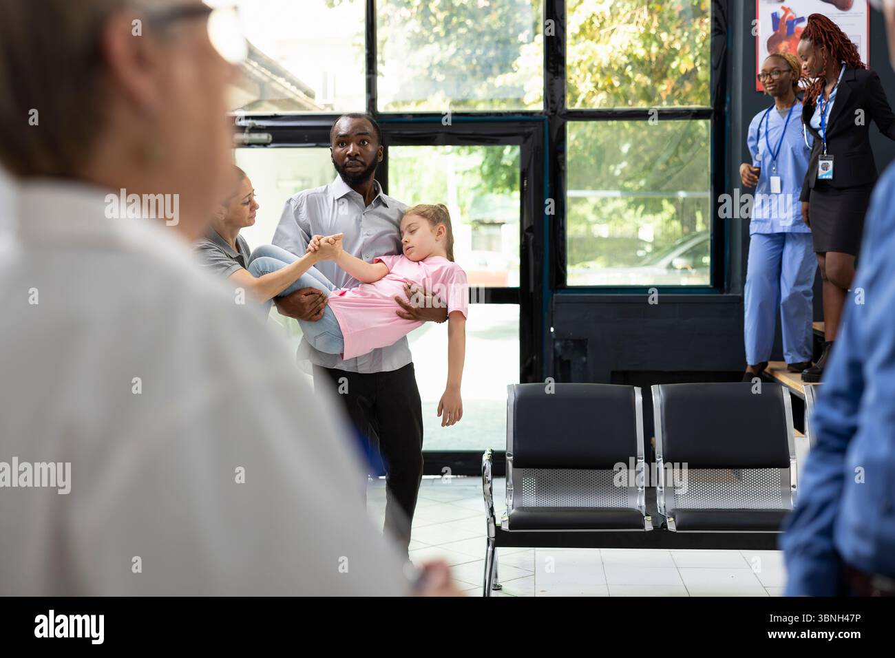 I membri della famiglia preoccupati reagiscono alla figlia inconscia in ambiente ospedaliero, affidandosi a personale sanitario professionale per cure di crisi e cure urgenti per il salvataggio della vita. Emergenza. Foto Stock