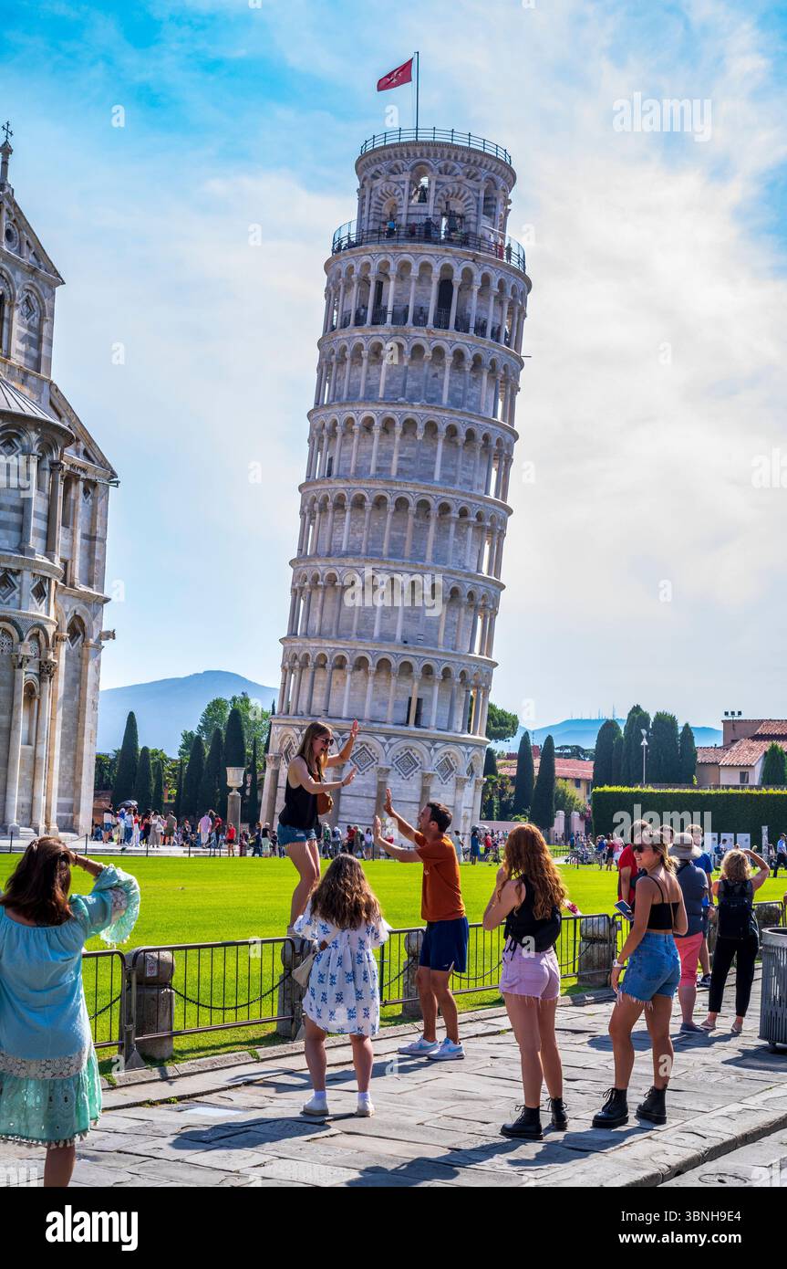 I turisti che scattano fotografie alla famosa Torre Pendente di Pisa in Piazza del Duomo - il campanile, campanile autoportante, attira visitatori di tutto il mondo Foto Stock