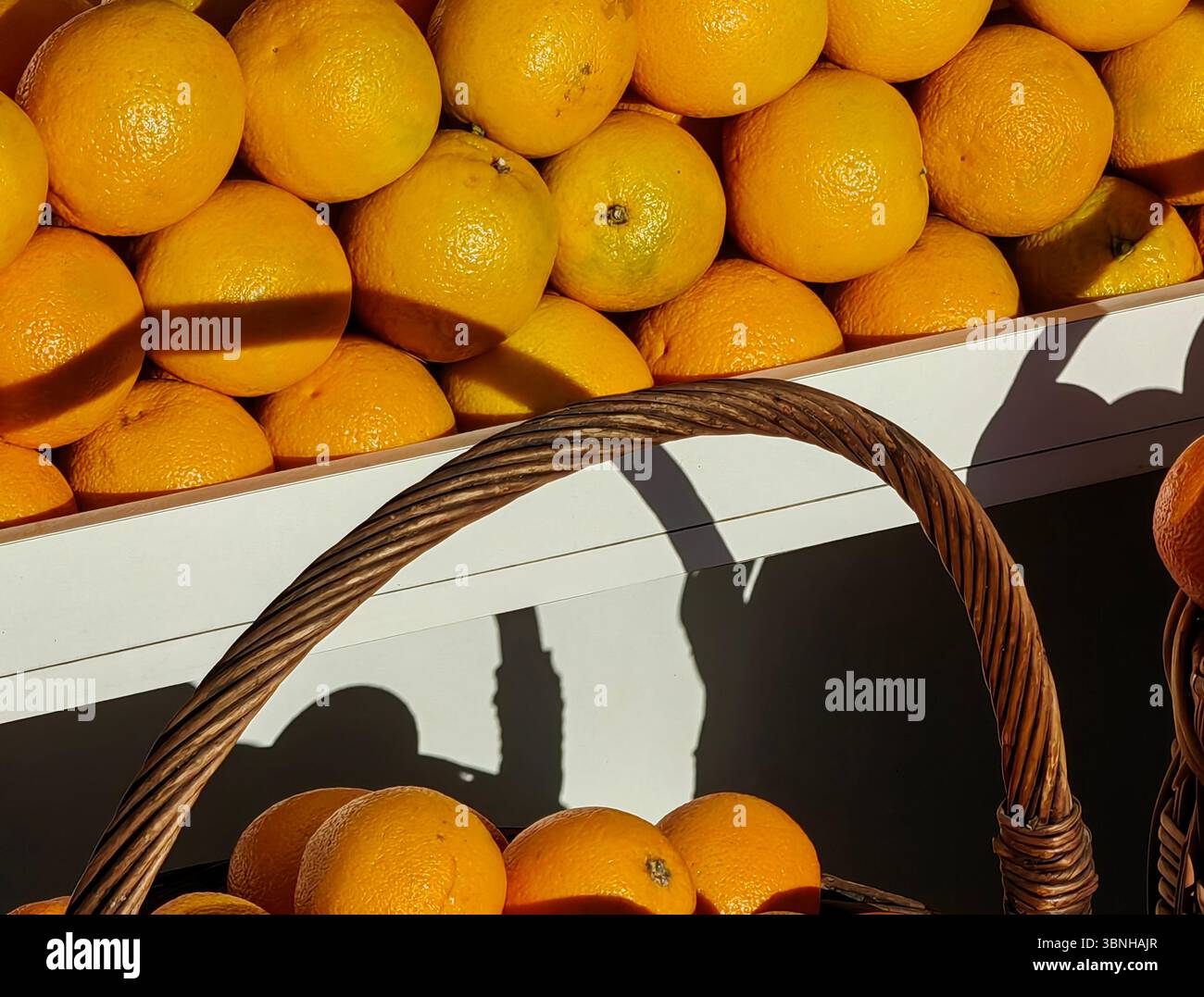Frutta d'arancia al sole nel cestino del mercato all'aperto Foto Stock