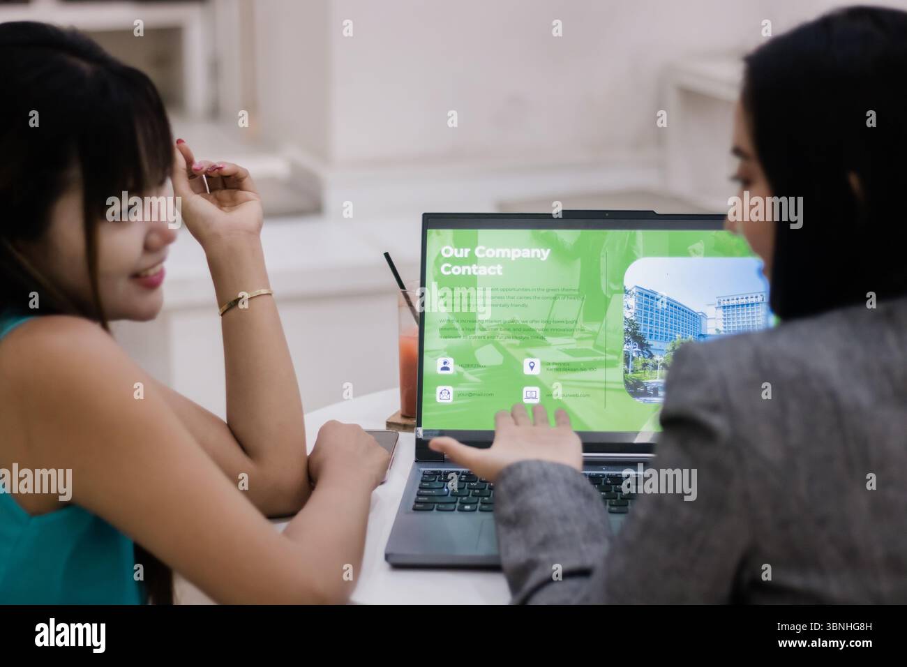 Due donne d'affari che collaborano. Esaminano una proposta aziendale presentata su un notebook. Condividere idee e parlare di una nuova strategia di progetto Foto Stock