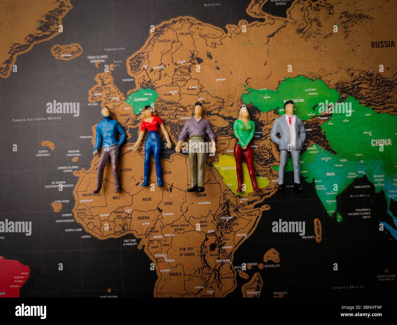 Uomini e donne in miniatura si trovano su una mappa del mondo. Concetto di geopolitica. Foto Stock