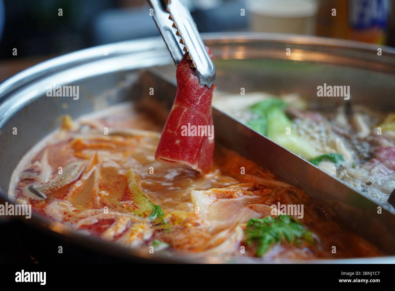 Hot Pot con carne a fette sottili e verdure fresche – primo piano del momento di cottura Foto Stock