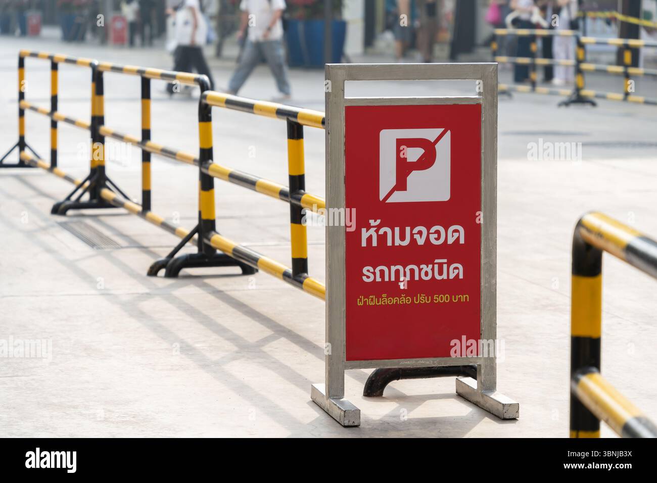 Questo è un cartello senza parcheggio dalla Thailandia, scritto in tailandese. Significa che nessun parcheggio per tutti i tipi di veicoli e i trasgressori avranno le ruote bloccate Foto Stock