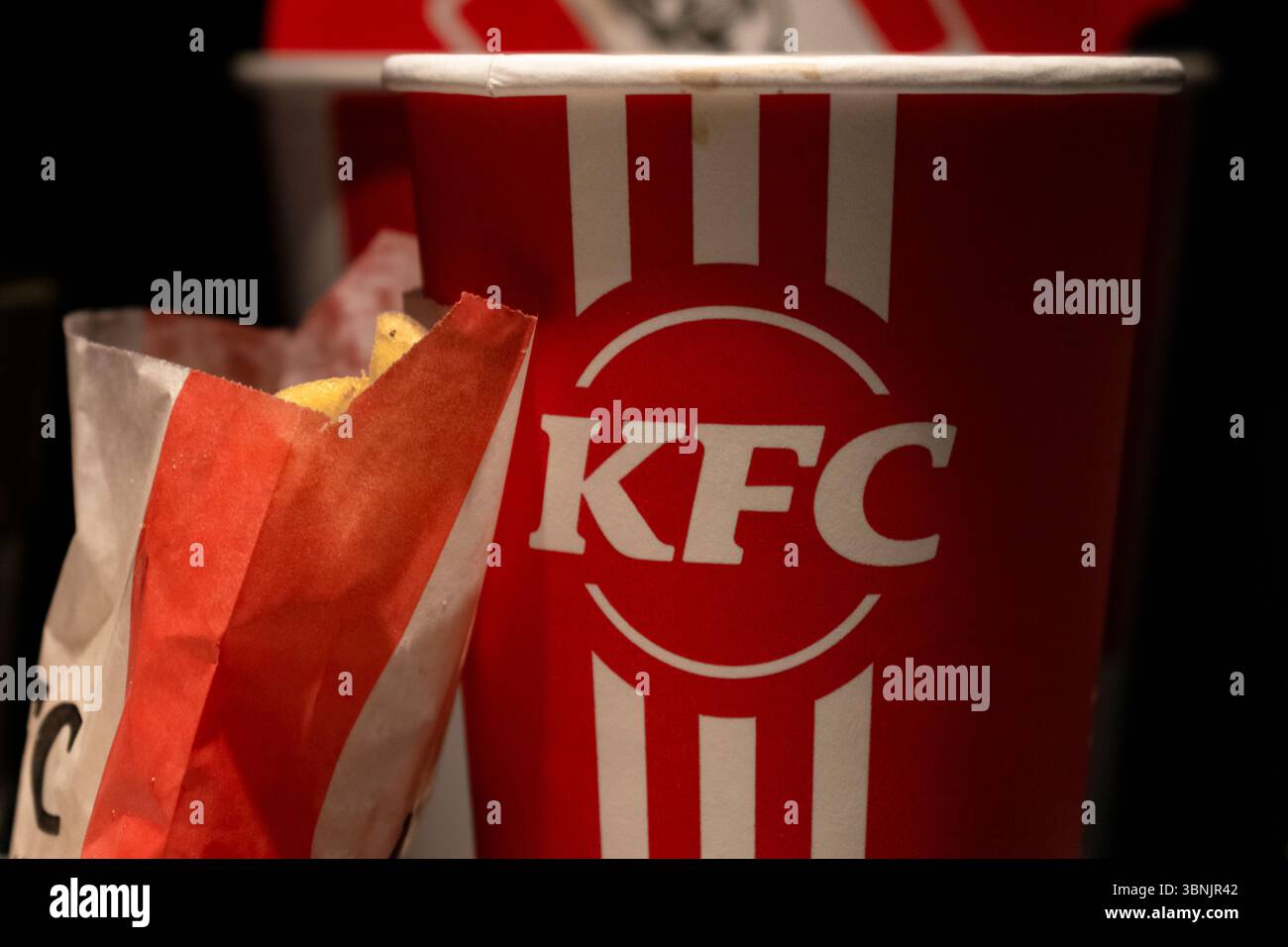 Primo piano della confezione KFC con patatine fritte e tazza per bevande. Foto Stock