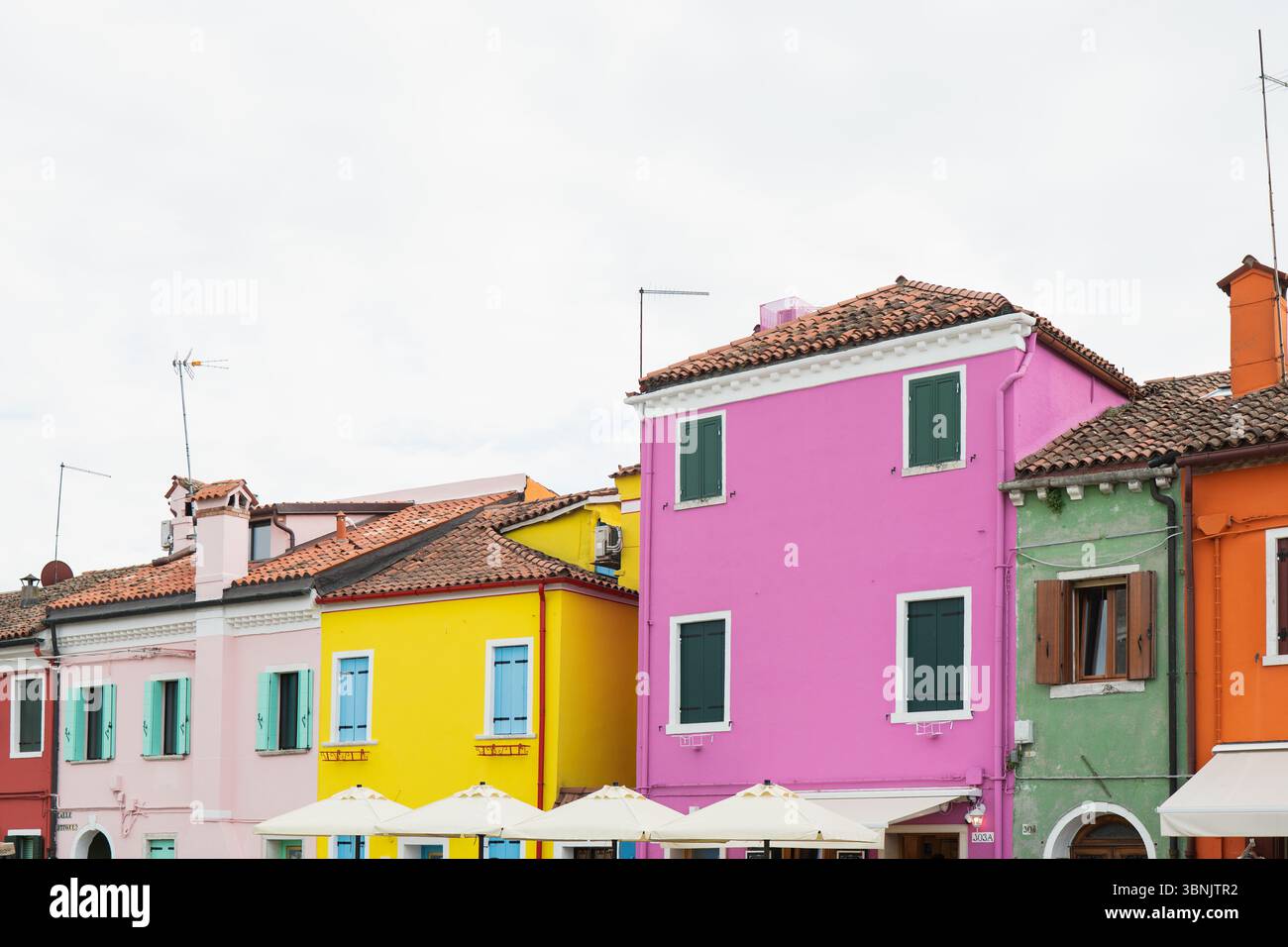 Edifici vivaci e colorati fiancheggiano le strade di Murano e Burano, Venezia. Questa immagine cattura il pittoresco, pittoresco fascino e l'architettura unica Foto Stock