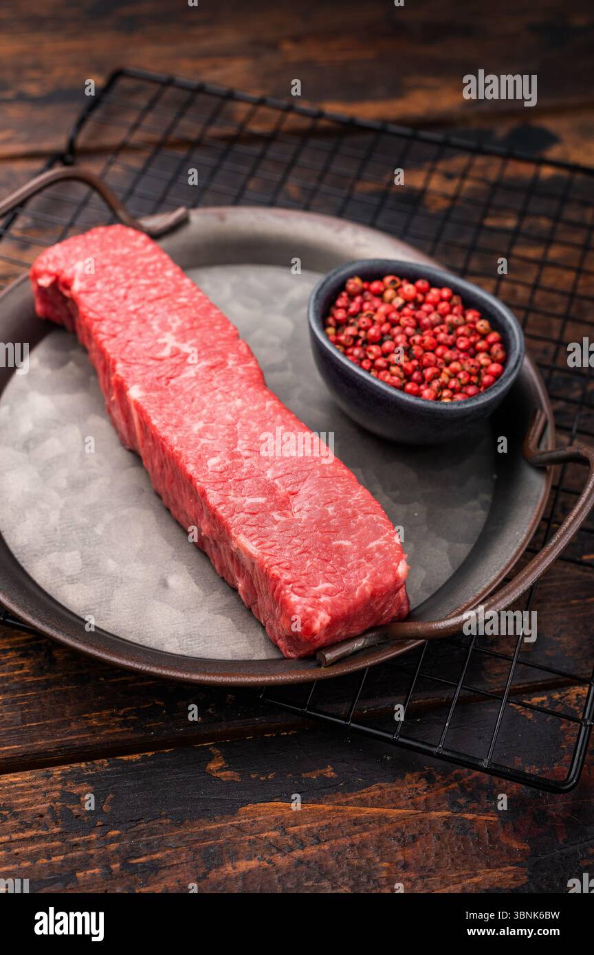 Bistecca di manzo wagyu marmorizzata di alta qualità, pronta per essere trasformata in un capolavoro gourmet. Una scelta deliziosa per il palato di qualsiasi amante della carne. dorso di legno Foto Stock