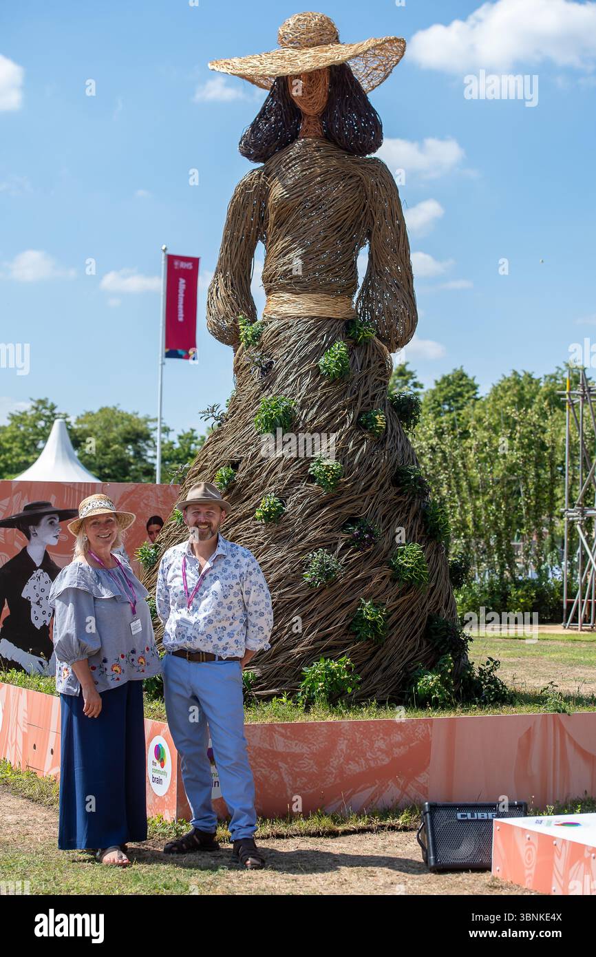 East Molesey, Surrey, Regno Unito. 30 giugno 2025. Una figura di Jane Austen in vimini al RHS Hampton Court Palace Garden Festival 2025 realizzata dagli artisti ambientali Rebecca e Mark Ford (nella foto) che celebrano i 60 anni di moda a Kingston. Gli artisti contemporanei Mark Antony Haden Ford e Rebecca Ford di due cerchi Design lavorano con materiali naturali. Lavorando nel loro studio a Slindon, all'interno del South Downs National Park, sia per il settore pubblico che per quello privato. Entrambi hanno un forte interesse per l'archeologia, la geografia e le meraviglie del mondo naturale, attingendo alle tradizioni e alle tecniche del salice Foto Stock